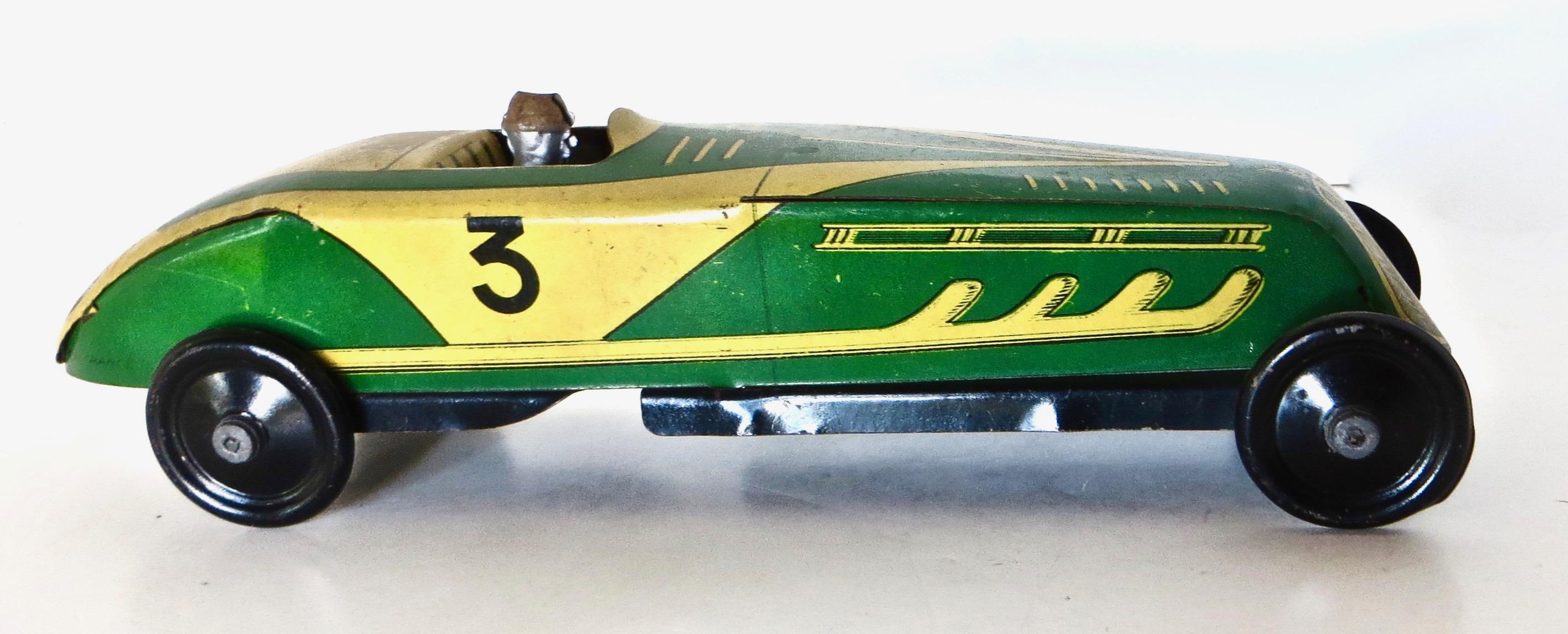 Circa 1930's free wheeling green lithographed all tin racing car, with attached pressed steel driver; it is probably of French manufacturer (the only time I have seen for sale was from a French toy dealer). This scarce toy has markings resembling