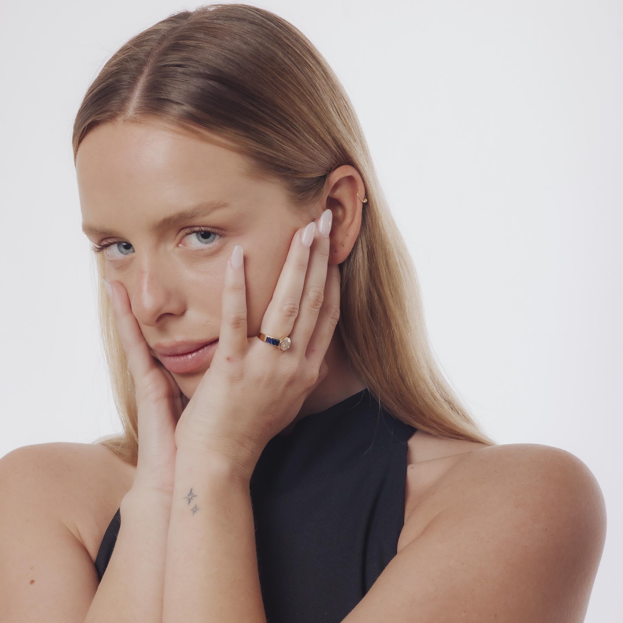 Questo anello vintage degli anni '80 presenta un diamante da 1,20 carati incorniciato da otto zaffiri baguette, il tutto incastonato in un ricco oro giallo 18 carati con marchio francese.