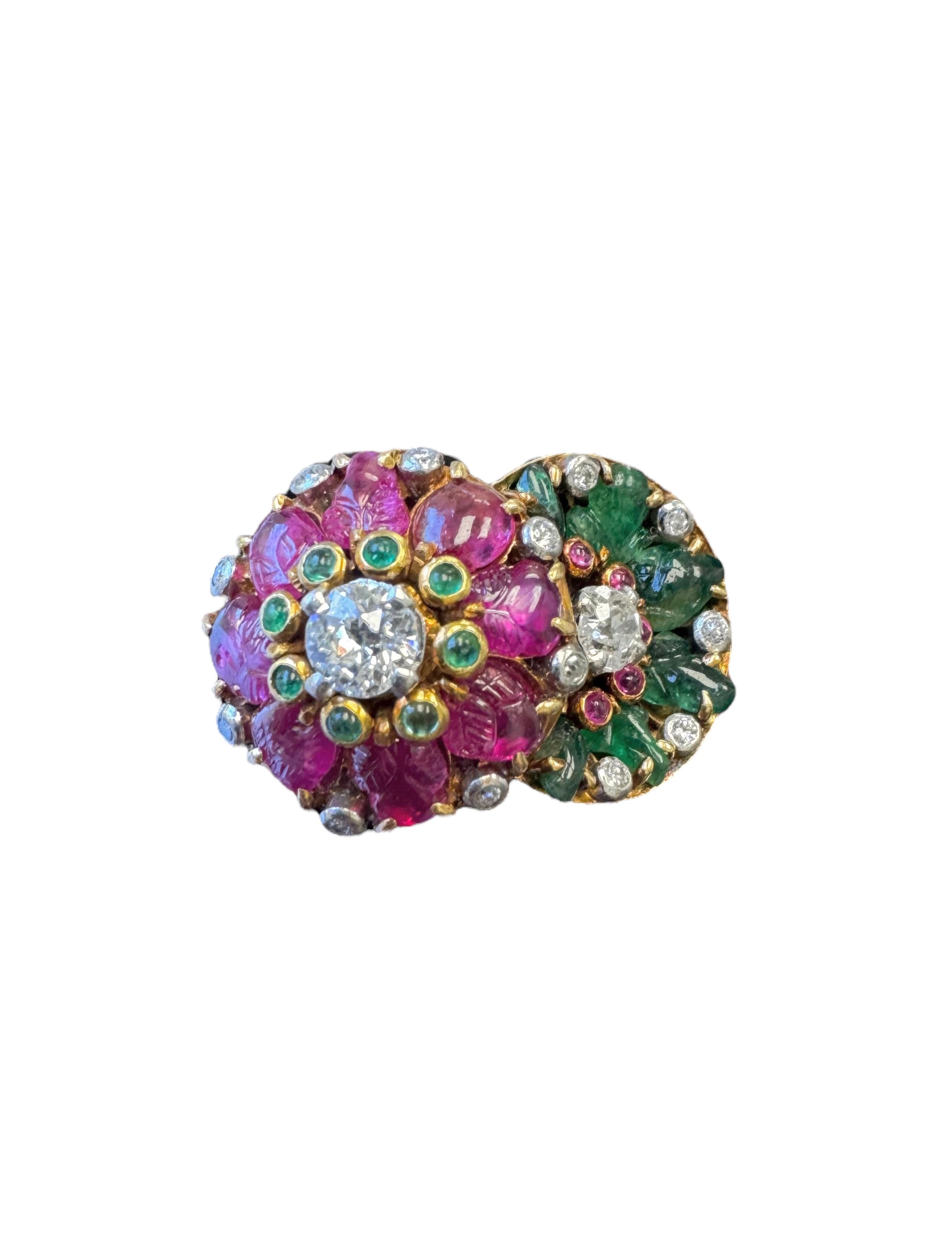 Une bague de cocktail vintage captivante et vibrante, réalisée en or jaune 14 carats, conçue comme un double motif floral qui se chevauche. Chaque fleur est ornée de pierres précieuses sculptées de façon complexe - une fleur en émeraudes vertes et