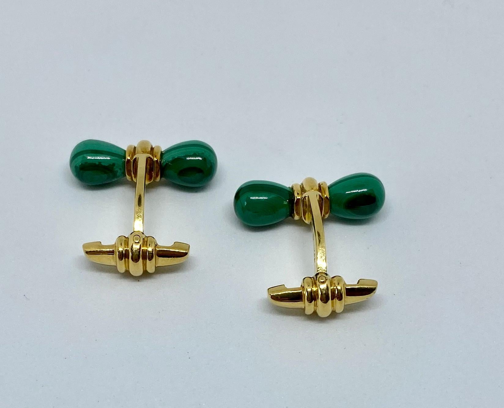 Bellissimi e insoliti gemelli a bastone realizzati in Francia e venduti da Alfred Dunhill. I gemelli presentano quattro vibranti malachiti intagliate per evidenziare le bande verdi naturali delle pietre, tutte incastonate in oro giallo 18