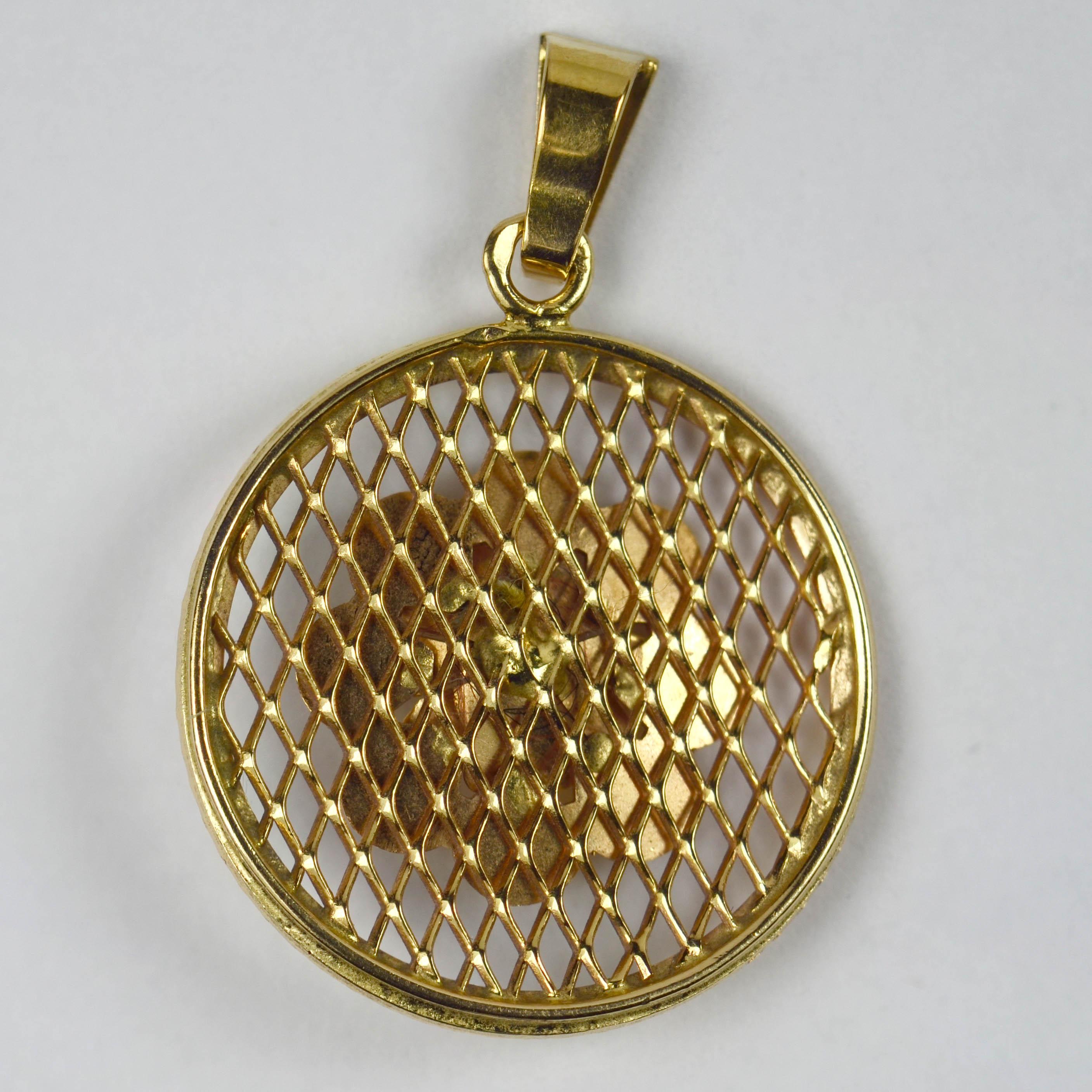 An 18 karat (18K) yellow gold charm pendant designed as a round medallion with filigree fretwork base and engine-turned flower rosette. Stamped with the eagle's head for 18 karat gold and French manufacture, with maker's mark for Charles Garnier of