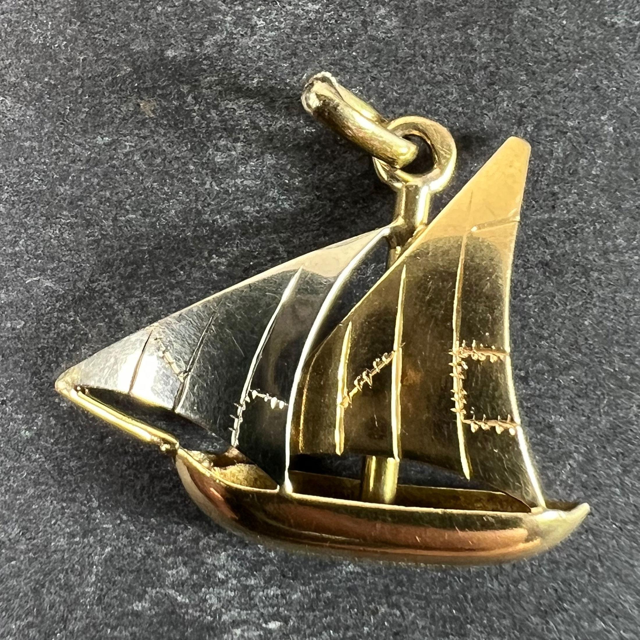 Ein französischer Anhänger aus 18 Karat (18K) Gelb- und Weißgold in Form einer Segelyacht oder eines Bootes mit einem Hauptsegel aus Gelbgold und einem Spinnaker aus Weißgold. Auf den Segeln sind Flicken eingraviert. Gestempelt mit der