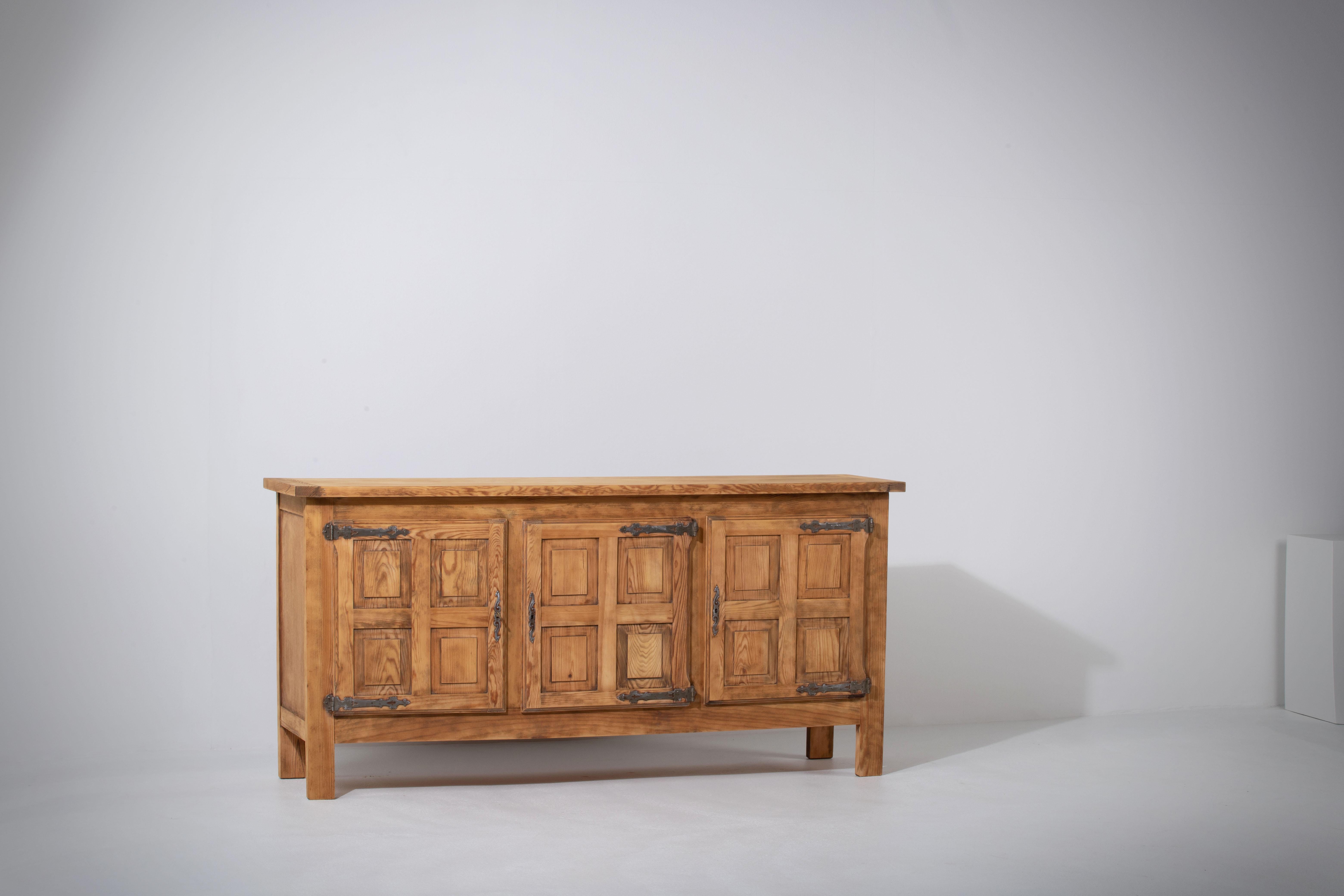 Presenting an impressive solid pine chalet sideboard, hailing from France in the 1950s. This substantial piece is a testament to traditional alpine cabin furniture, featuring a design characterized by straight lines and rustic simplicity.

Crafted