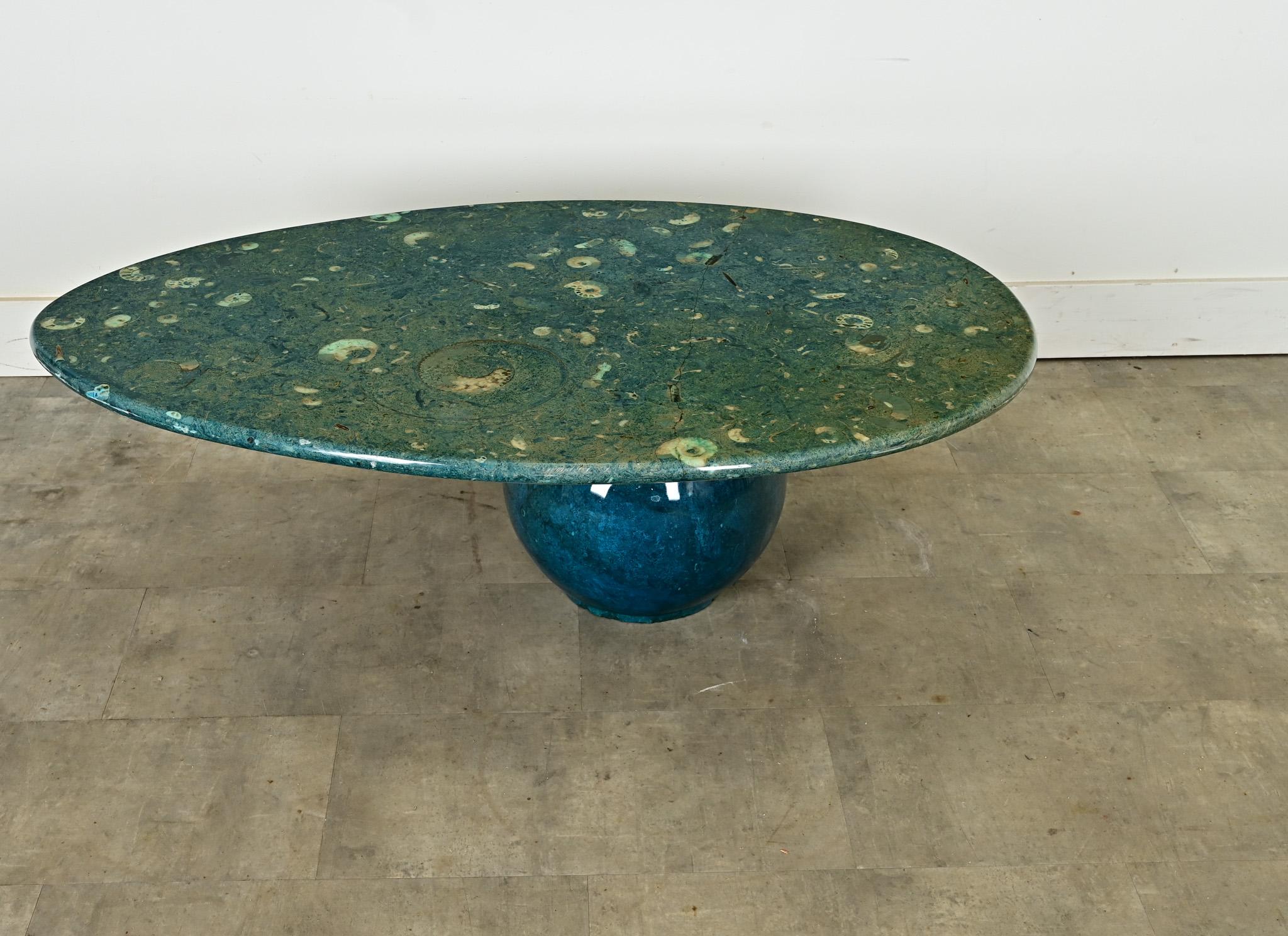 An imaginative and unique coffee table from 1970s France, featuring a hypnotic array of fossilized nautilus shells embedded in a blue-green stone as if it was transported right out of the ocean. The sculptural form is made of two parts: an oval