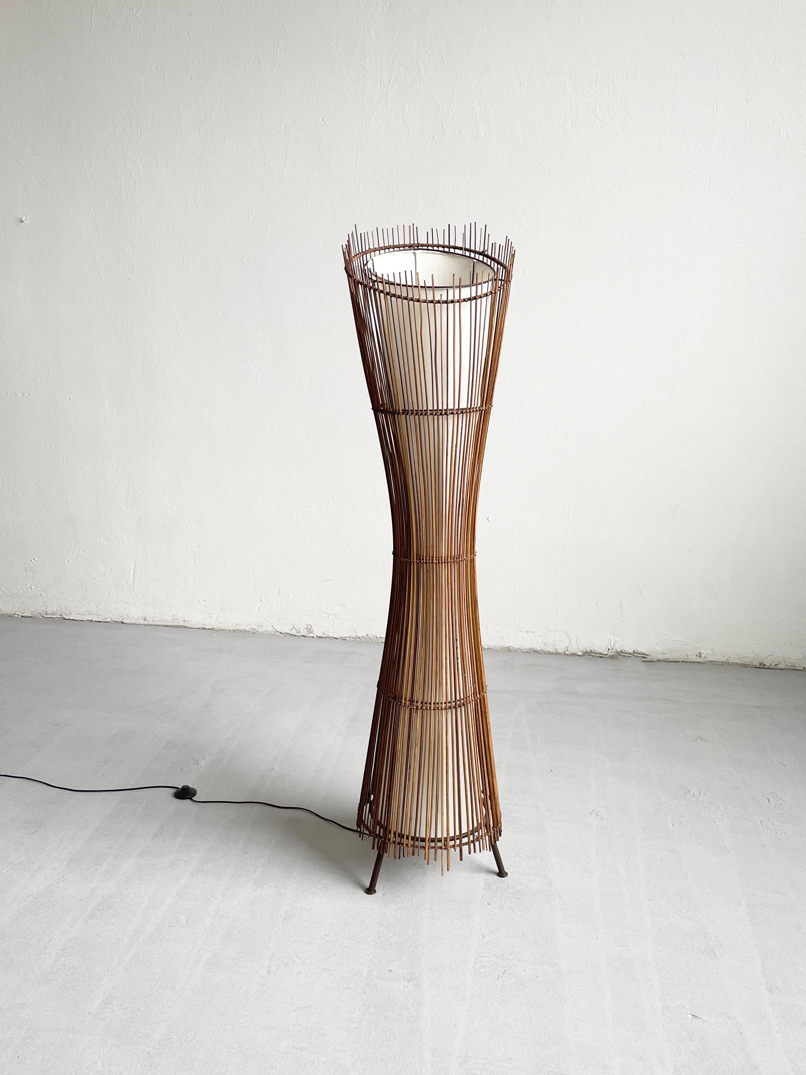 Ce lampadaire sculptural a été fabriqué en France dans les années 1980. 
Il présente une belle forme organique faite d'une armature en fer et de bambou. L'abat-jour intérieur est en toile blanche 

La lampe est équipée de trois douilles européennes