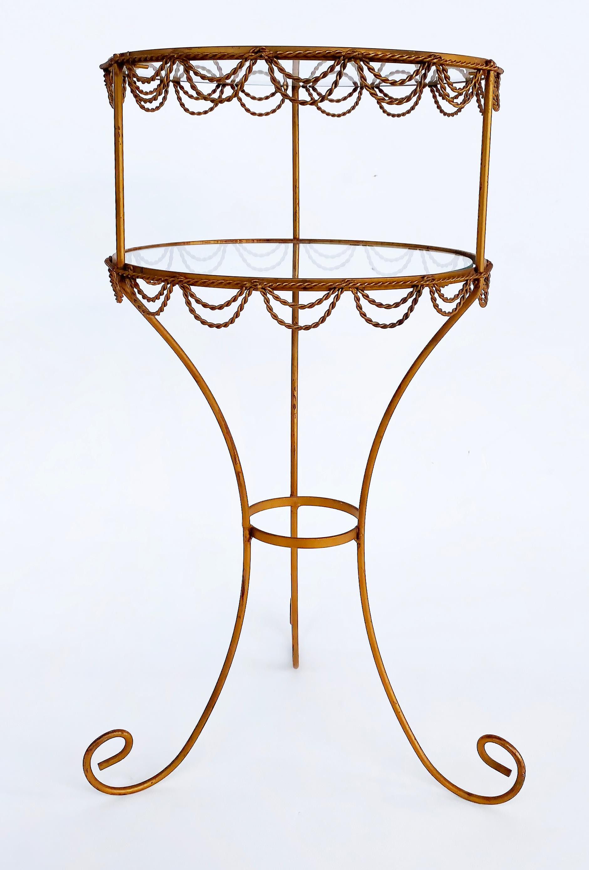 Vintage French 2-tiered Gilt Iron Side Table Stand with Inset Glass 

Offered for sale is a delicately designed French gilt-iron two-tier side table or stand.  The round table with curved legs is trimmed in twisted gilt-wire swag details. The top