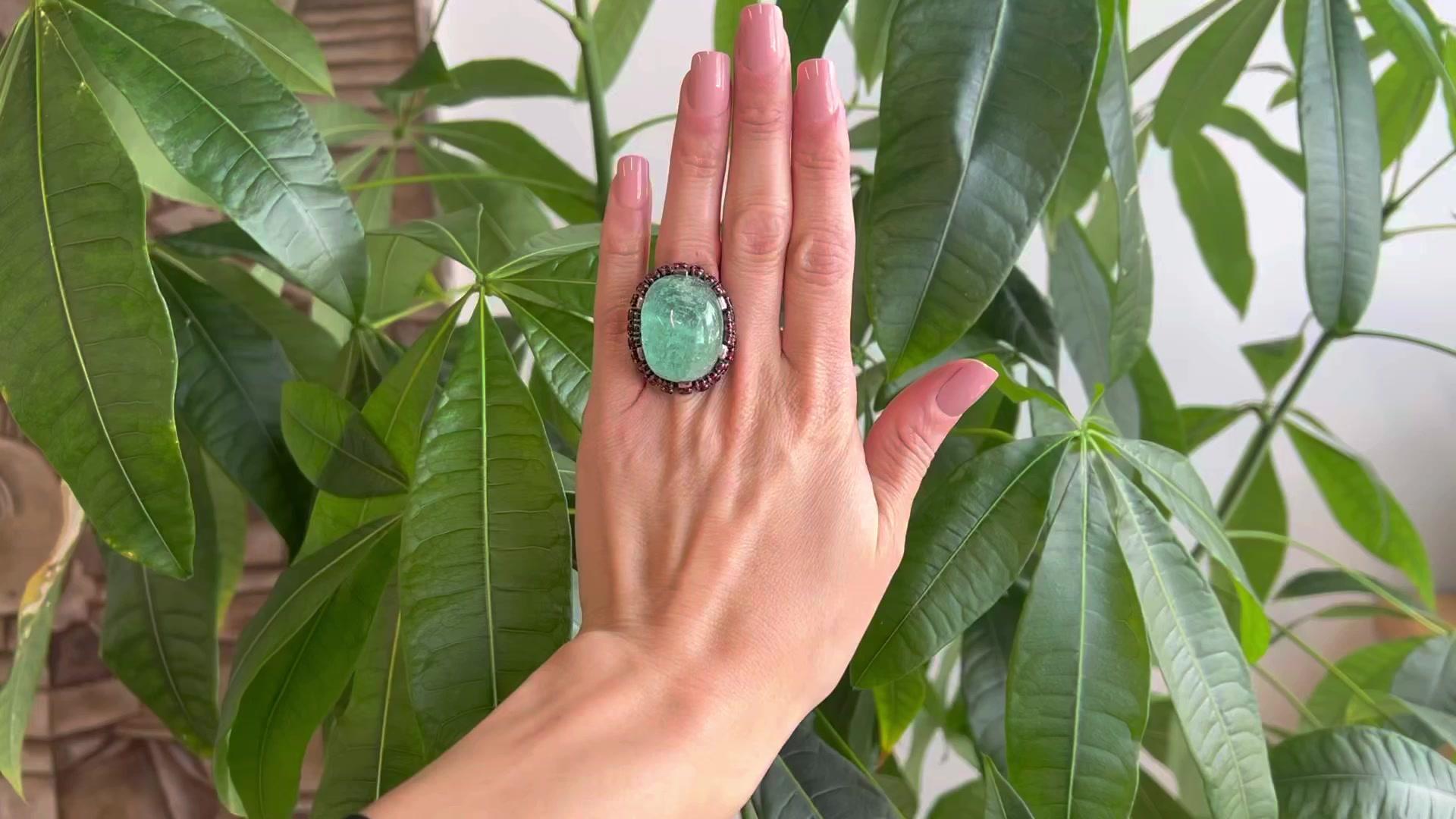 One Vintage French 75.00 Carat Emerald Garnet Silver Statement Cocktail Ring. Featuring one cabochon emerald weighing approximately 75.00 carats. Accented by 54 round brilliant cut garnets with a total weight of approximately 7.45 carats. Crafted in