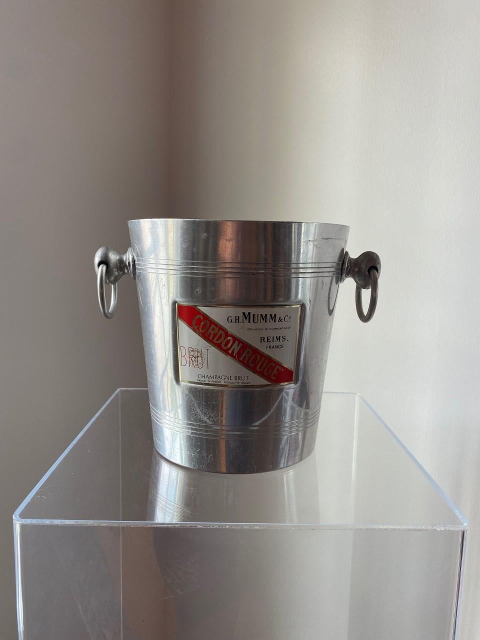 These aluminum champagne buckets were used in the 1950s and 1960s, and typically were marked with the vintner's name. They're great for chilling wine, for flowers, or for just about anything. This piece is especially nice with a bottle of wine from