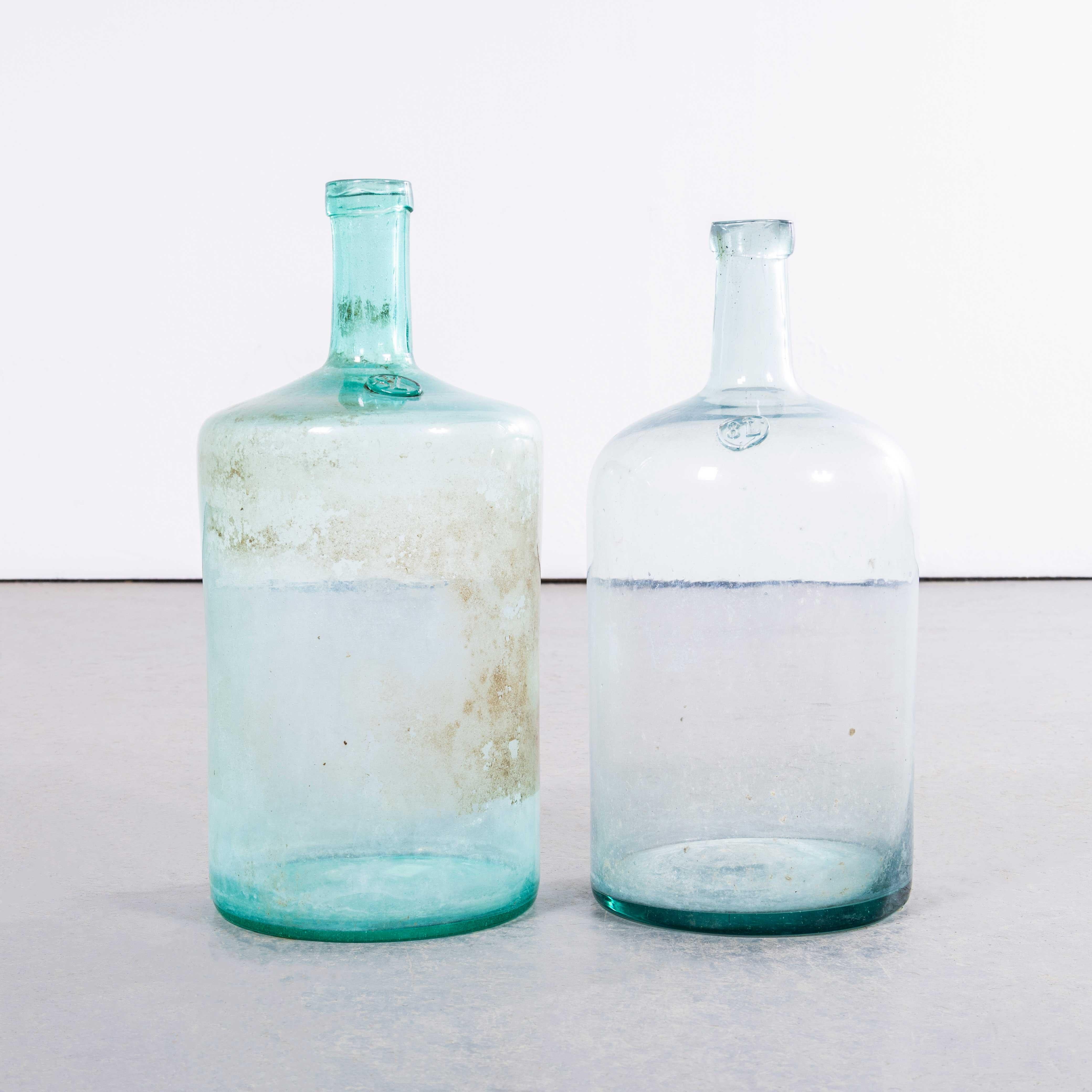 Damigiane francesi vintage in vetro trasparente e acqua - Coppia. 

Una coppia di damigiane in vetro soffiato a bocca utilizzate come contenitori tradizionali principalmente per la conservazione e il trasporto del vino. Queste damigiane sono state