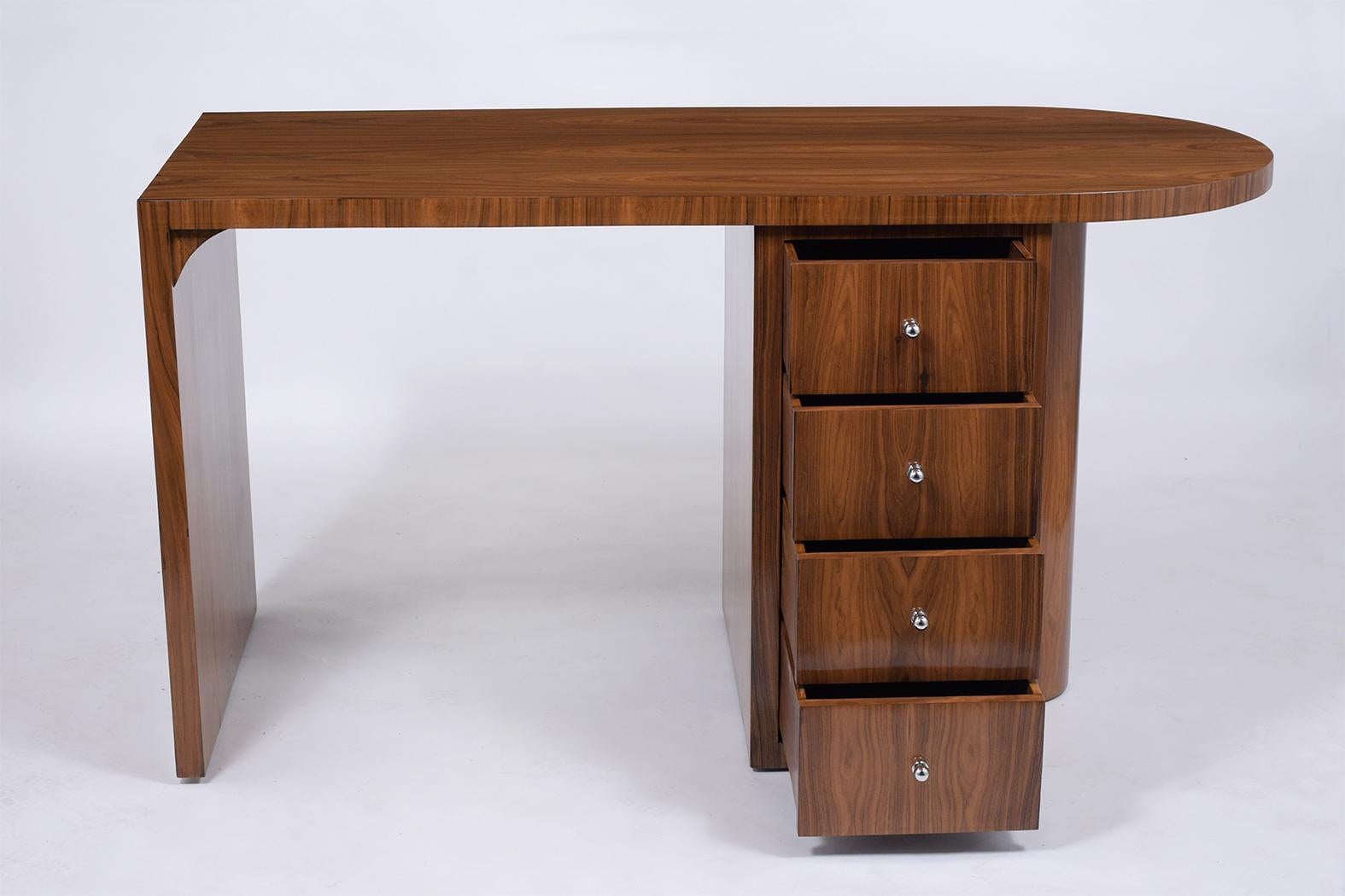 An extraordinary vintage Art Deco desk finely crafted out of exotic kingwood with a newly lacquered finish and is fully restored. This writing table is eye-catching features an L design with a stylish oval top, and a pedestal cabinet that comes with
