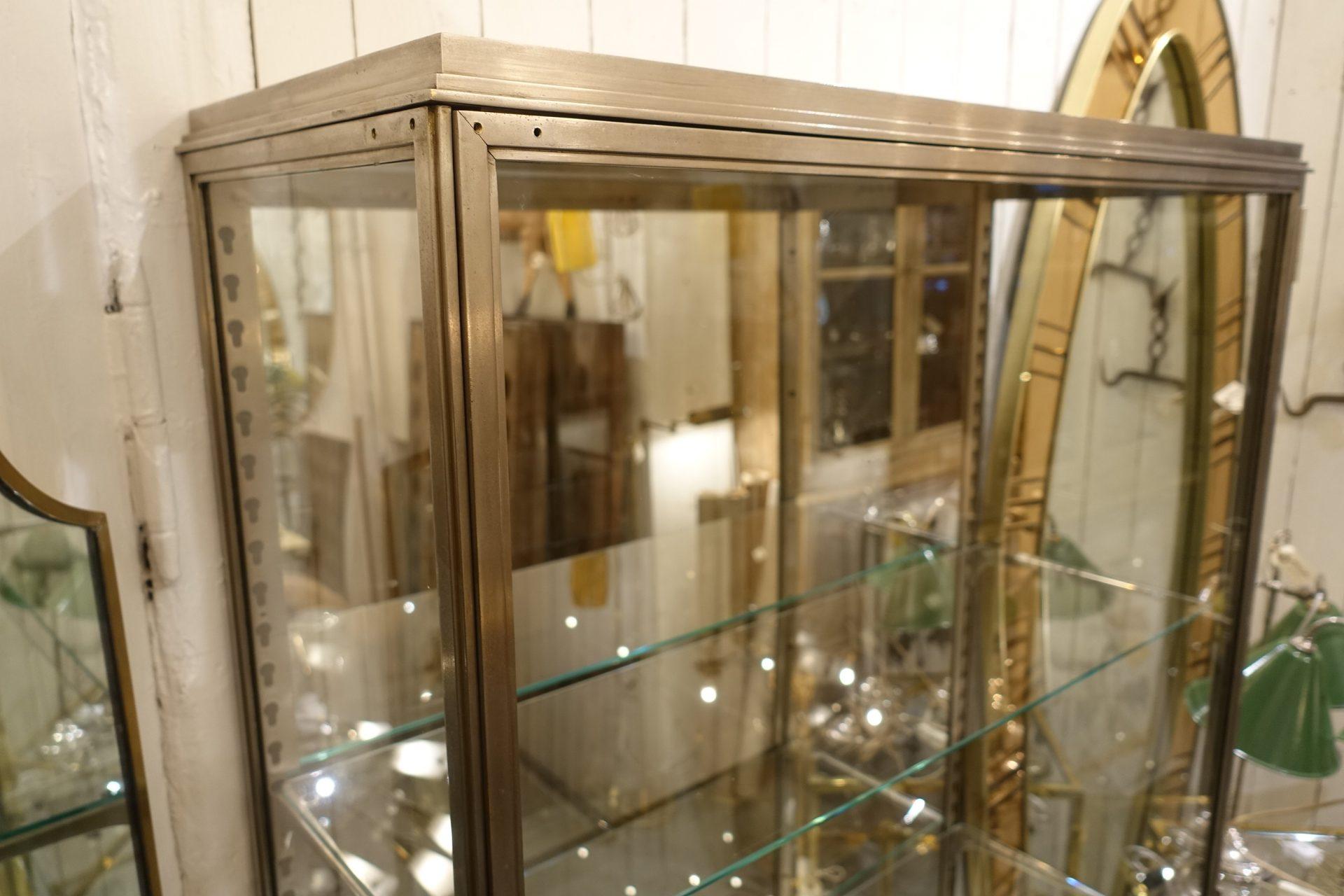 Vintage French Art Deco display cabinet / vitrine, from circa 1930s. Manufactured at Siegel in Paris. Made in nickel-plated brass, with 3 matching original glass adjustable shelves. The cabinet can be locked with a key and was once boutique
