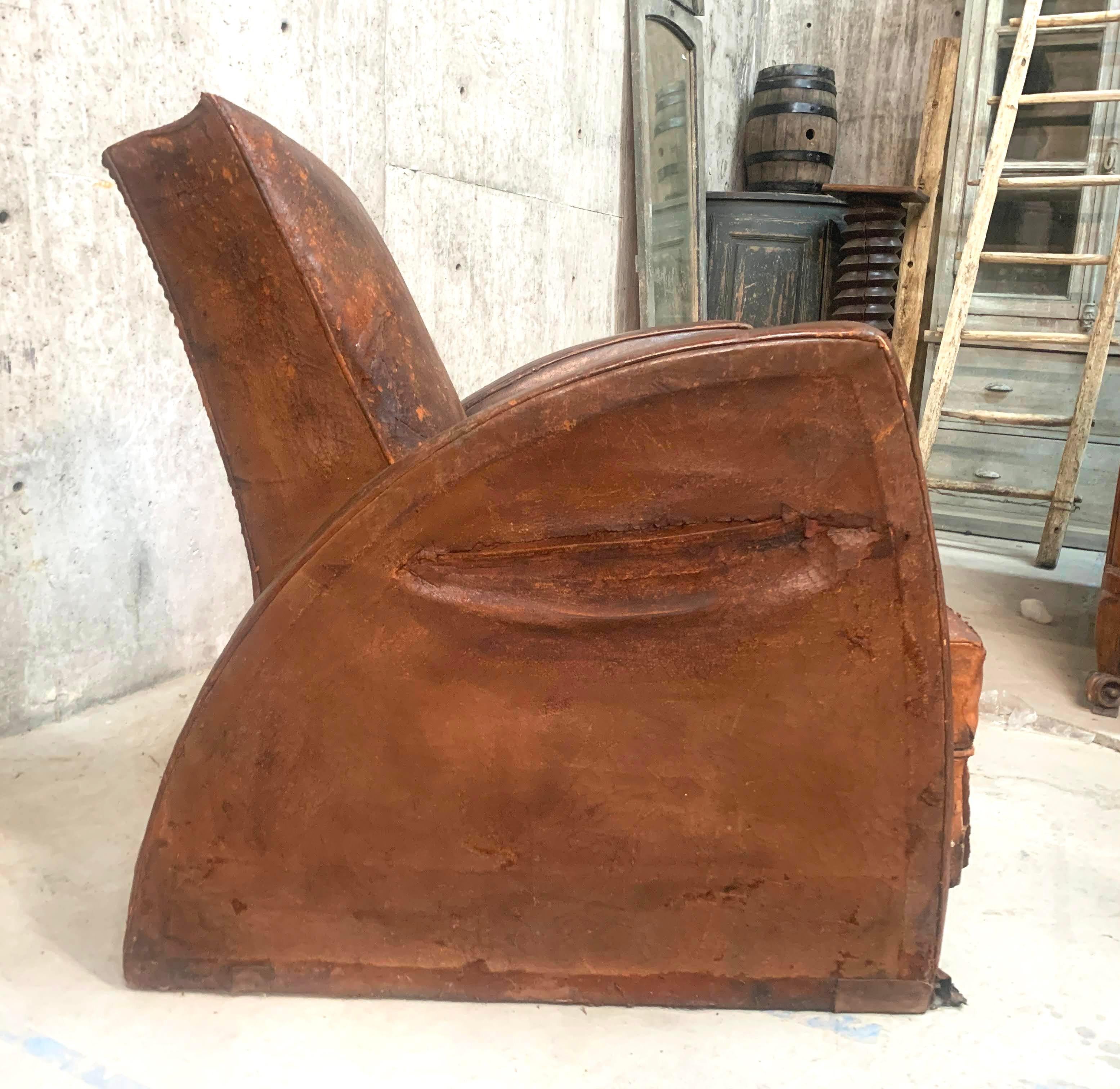 Rare French Art Deco leather club chair, c.1930s. Unique curves and lines characteristic of Art Deco style. Side pocket on arm for newspaper and magazine storage. Could benefit from restoration.

SH- 17