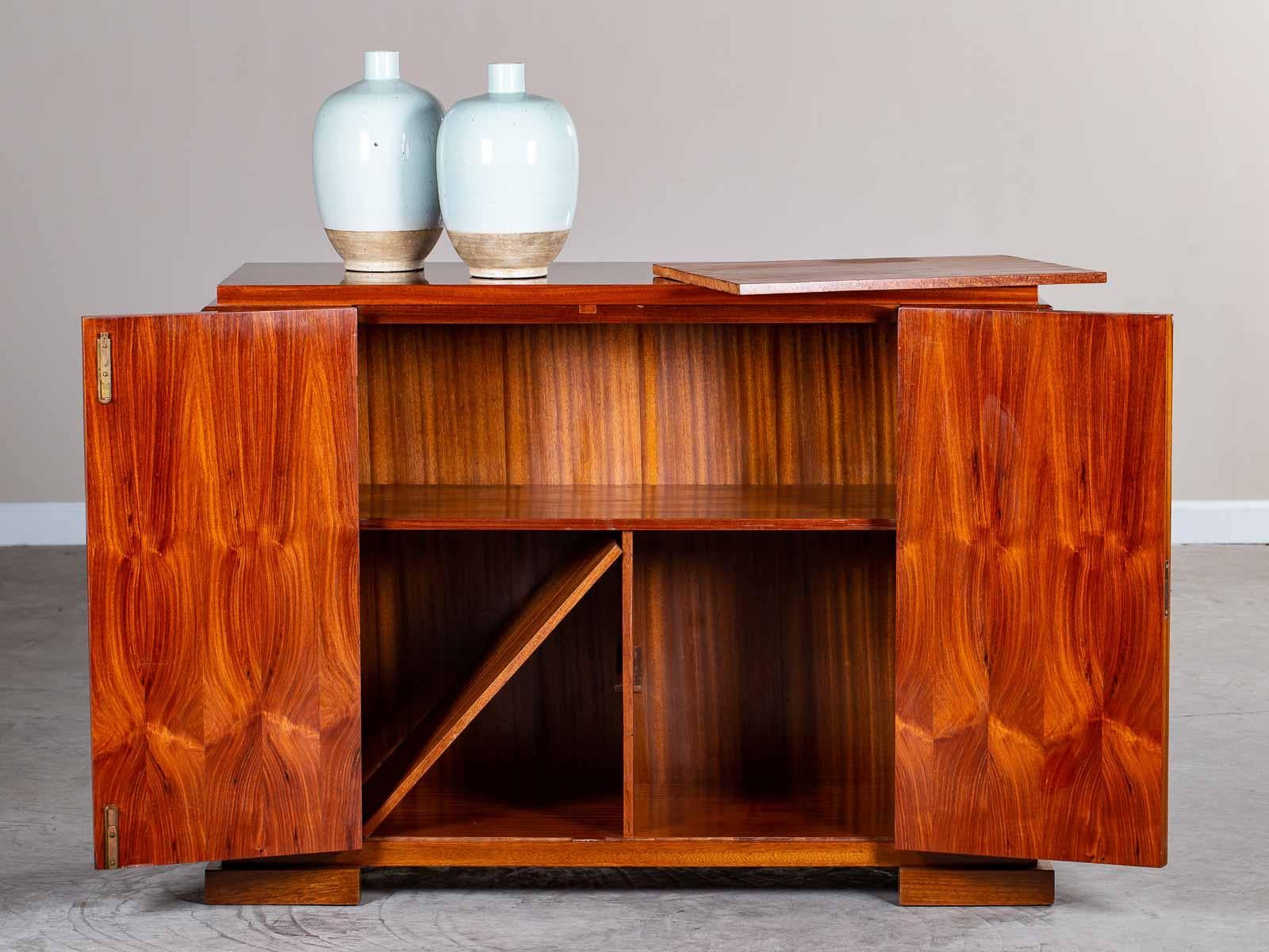 A vintage French Art Deco mahogany buffet credenza cabinet circa 1930 with a superb use of the mahogany grain to create a sense of movement across the façade. This exceptional two door vintage buffet cabinet showcases the cabinet making skill in
