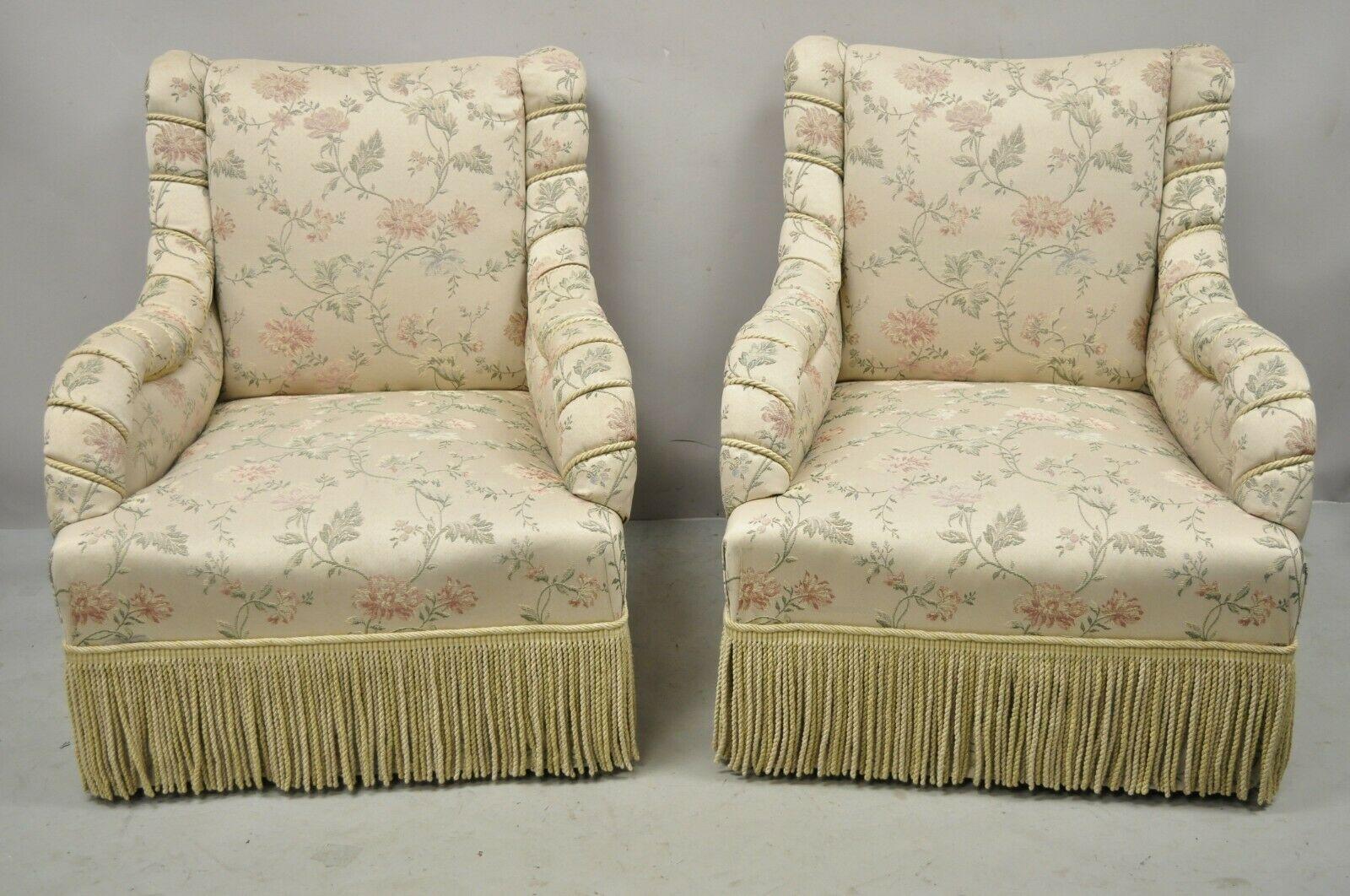 Vintage French Art Deco style rolled arm pink gold club lounge chairs - a pair. Item features brass rolling casters, fringe skirt, gold/pink/beige silk upholstery with floral print and rope wrapped arms, solid wood frames, very nice pair, quality