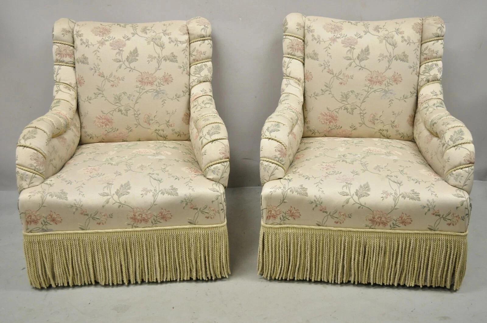 Vintage French Art Deco Style Rolled Arm Pink & Gold Club Lounge Chairs - a Pair. Cet article est doté de roulettes en laiton, d'une jupe à franges, d'un revêtement en soie or/rose/beige à imprimé floral et d'accoudoirs enveloppés de corde, d'un