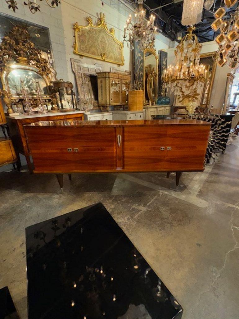 Ce buffet français vintage de style Art of Vintage est fabriqué dans un riche bois de noyer. Son design élégant et sa superbe finition polie en font une pièce remarquable pour tout espace de vie. L'influence Art déco du buffet est évidente dans ses