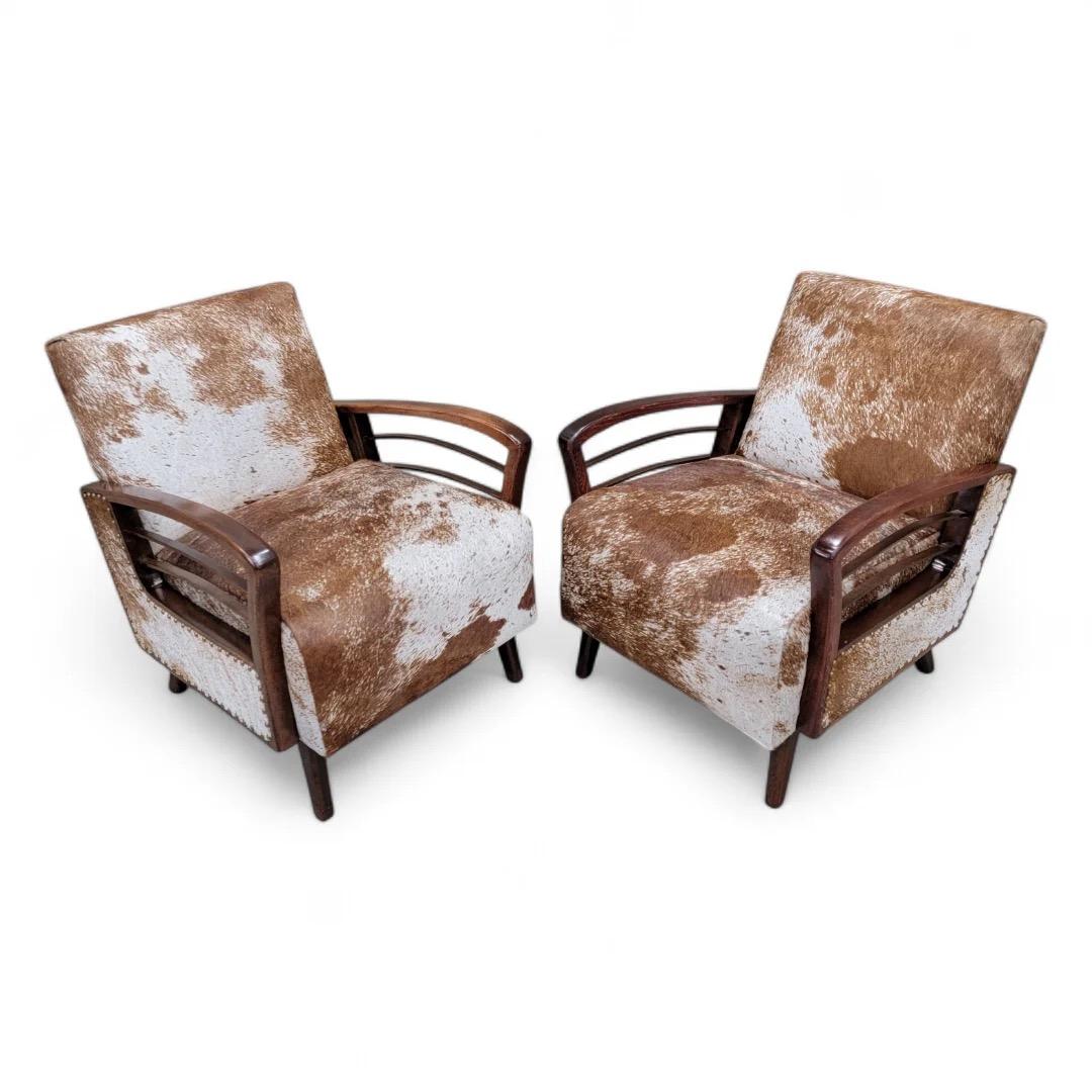 Vintage francés Art Deco Sillones con brazos en arco de madera recién tapizados en piel de vaca brasileña marrón sal y pimienta - Pareja 

Este exquisito par de sillones de salón Art Déco franceses vintage presenta un distintivo diseño de puente de
