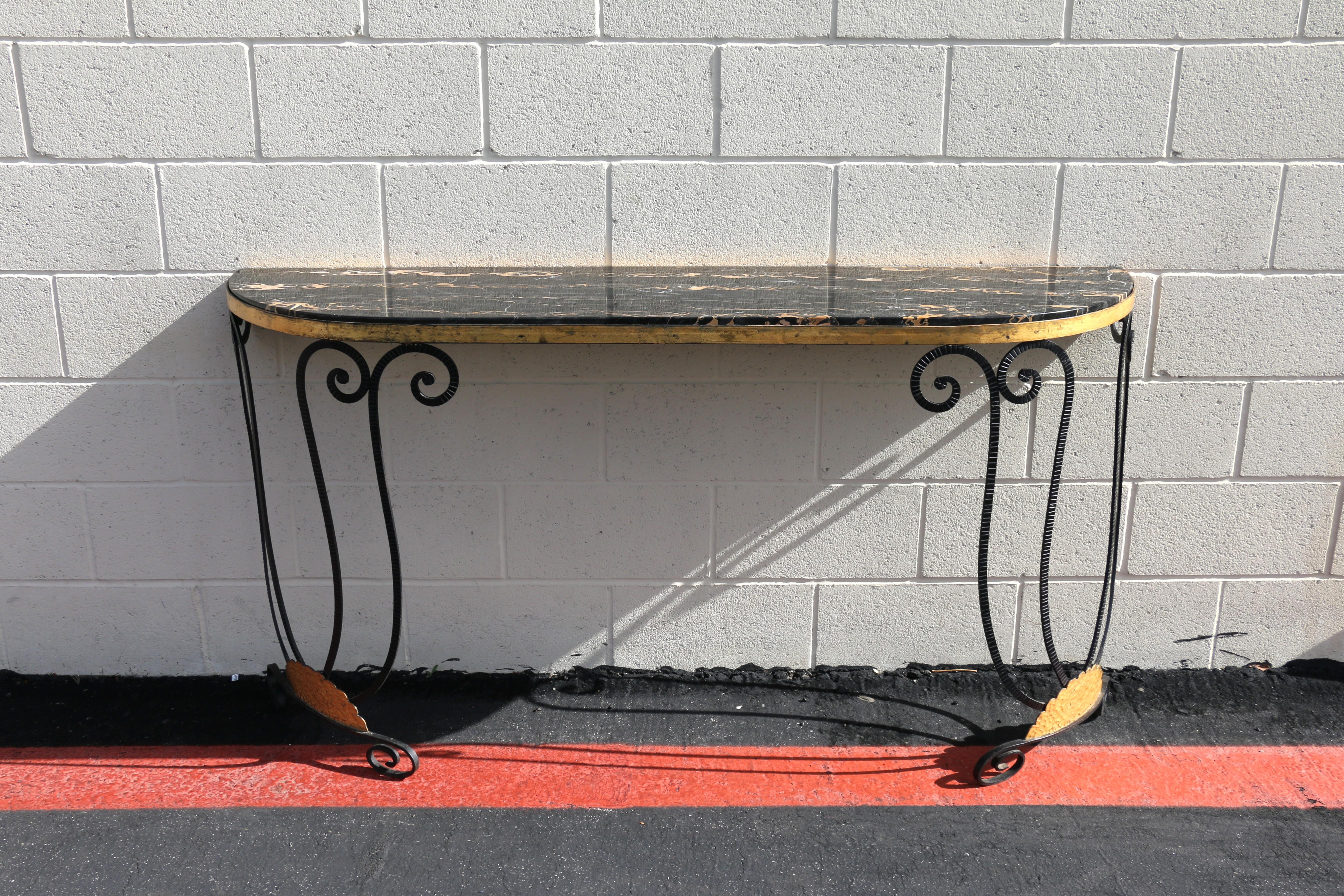Introducing this stunning vintage French Art Deco–style demi-lune (half-moon) console table featuring an elegant black marble top with striking golden veining. The wrought iron base showcases classic scrollwork and a warm gold-leaf accent, creating