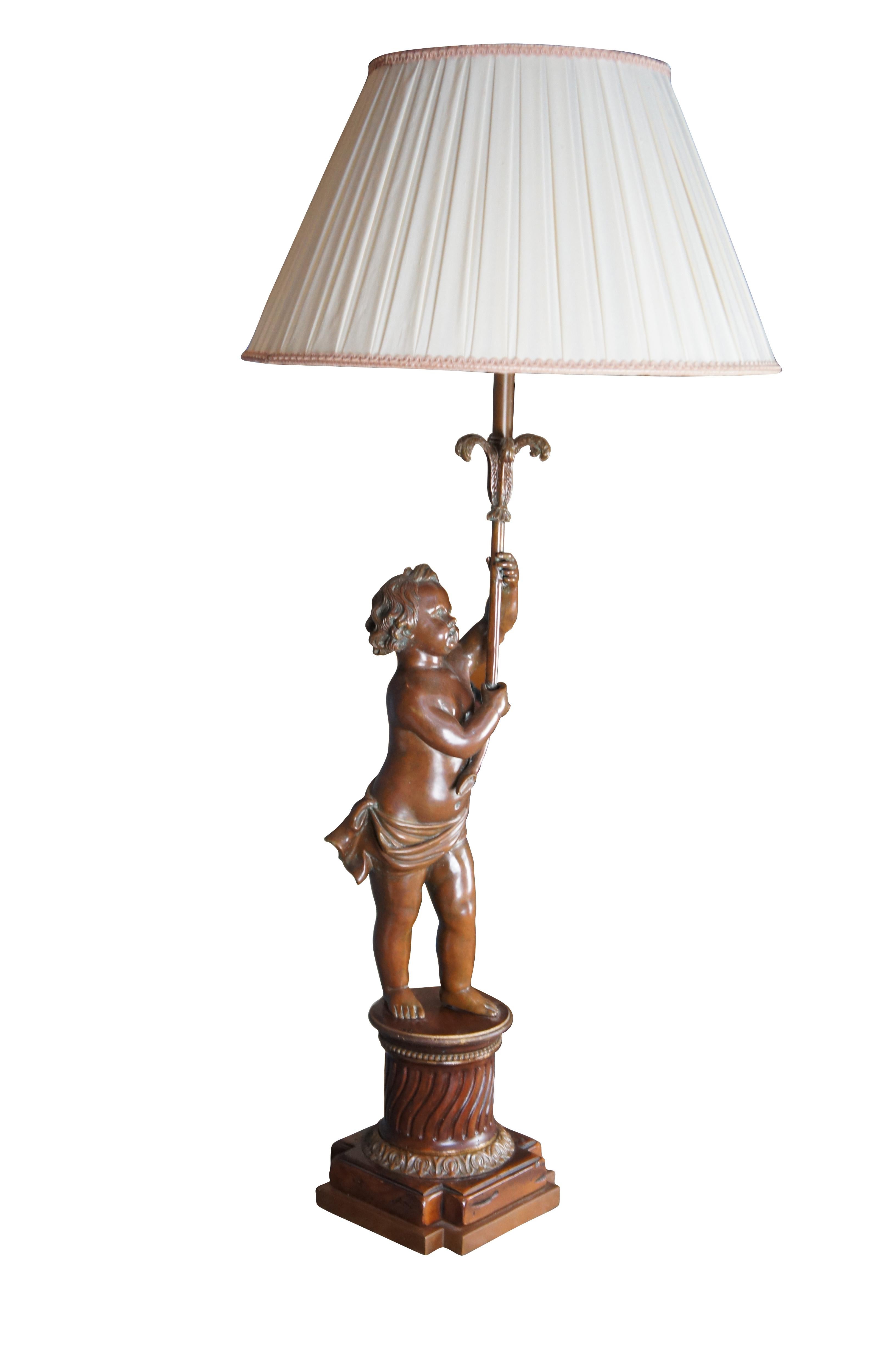 A beautiful French Art Nouveau style lamp, circa late 20th century. Features a bronze cherub holding an ornate Prince of Whales style candlestick over a Carved mahogany base. The base is Grecian style pedestal or stand with beading, fluting and