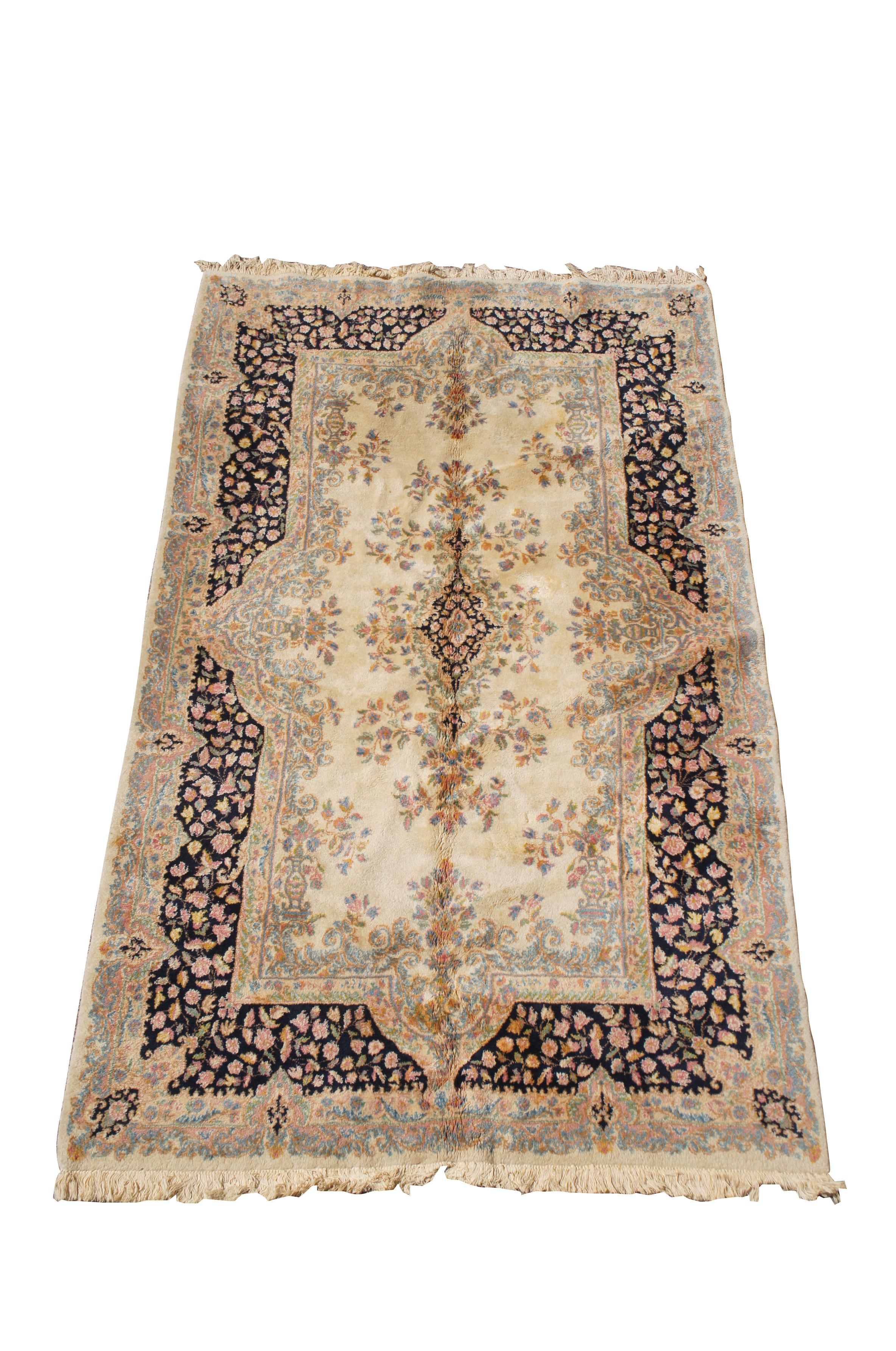 A classic French Aubusson rug, circa last half 20th century.  Features a beige foreground with light blue and navy border.  The rug is decorated with vibrant floral sprays in blue, gold, pink and orange. 225 knots per square inch

Dimensions:
59.5