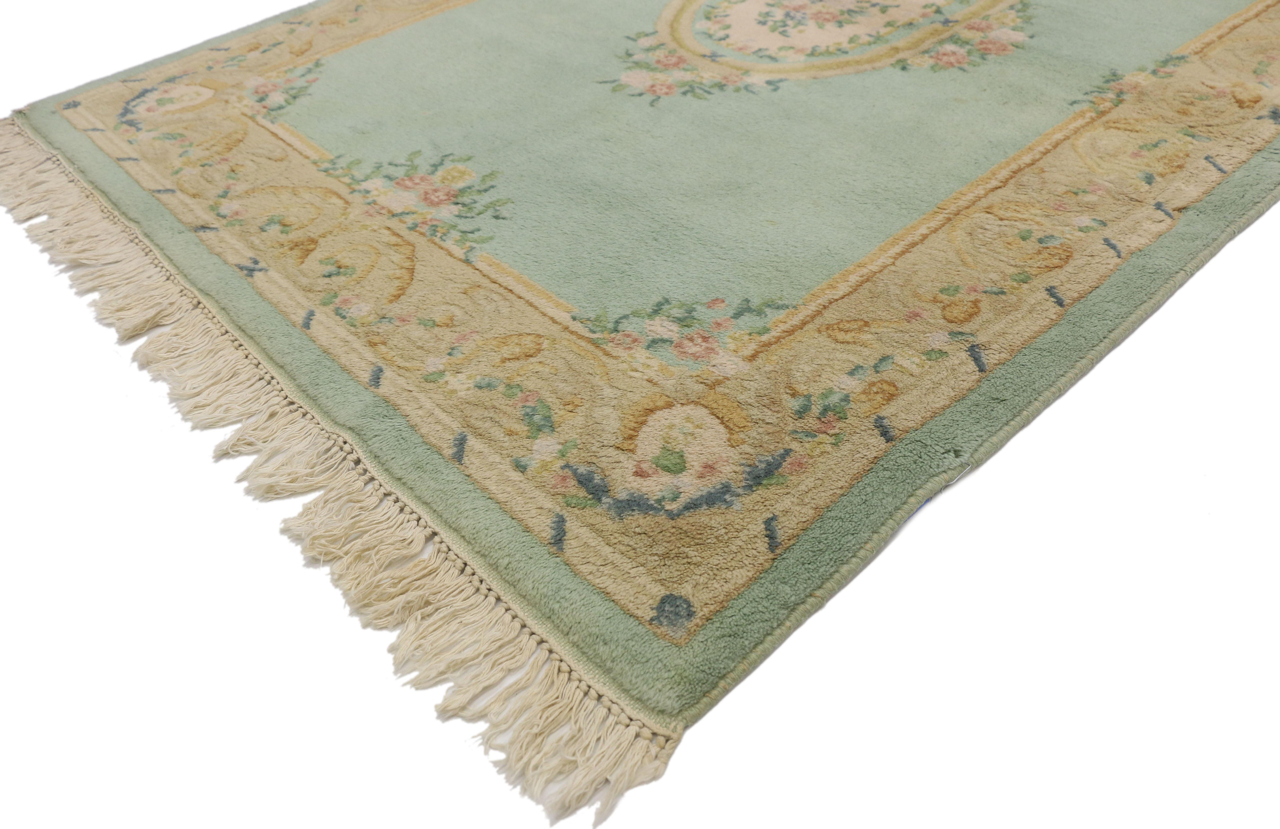 74741, vintage French Aubusson style rug with French Rococo Georgian style. This vintage French Aubusson style Indian rug features a creamy-beige center oval medallion filled with dense florals, roses, and leafy tendrils in an open abrashed field.