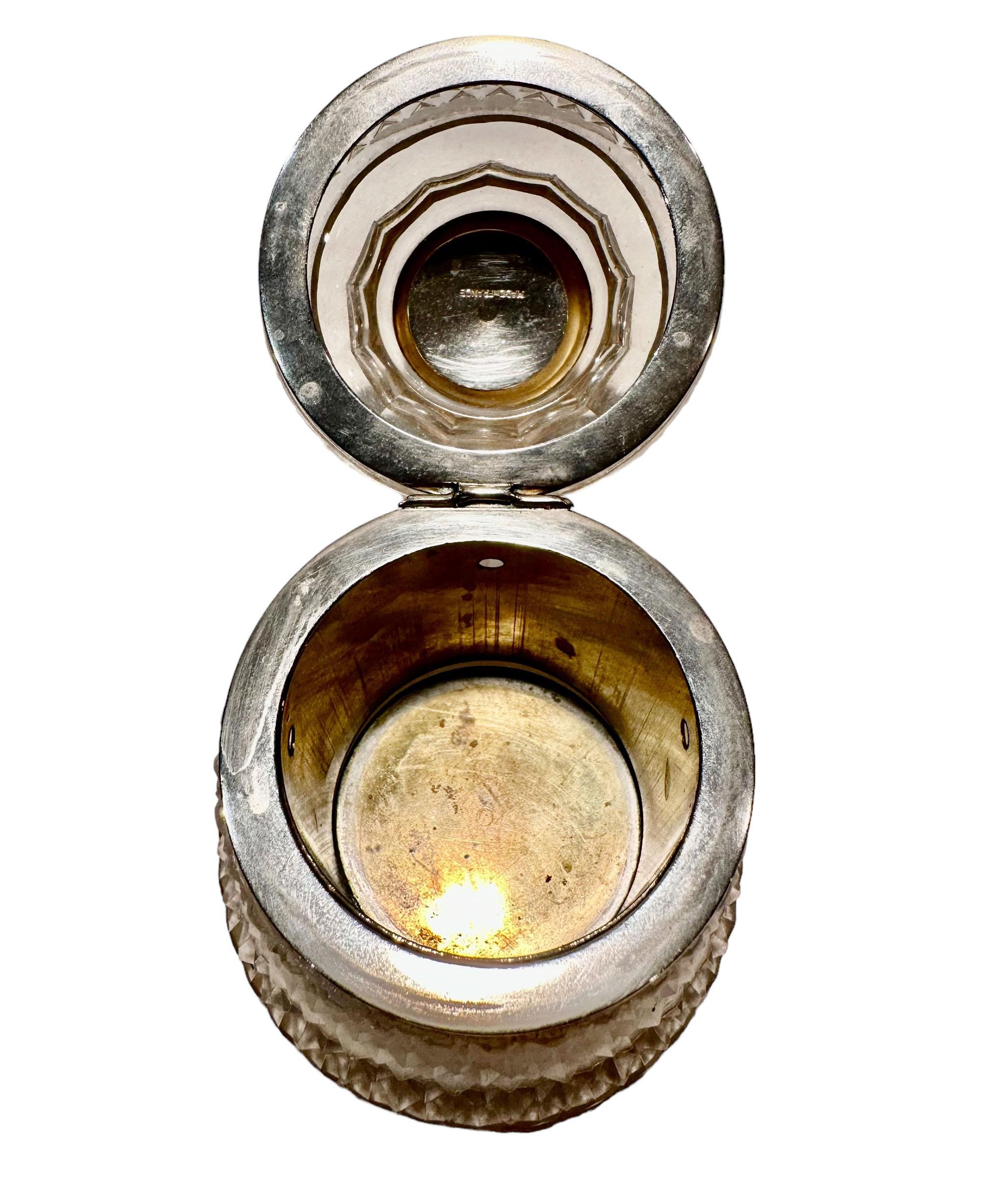 Se trata de una fascinante pitillera de cristal estilo Baccarat con forma de campana. Es de latón con acabado plateado y un diseño neoclásico con una anilla para abrir la caja. Francés, hacia 1940.