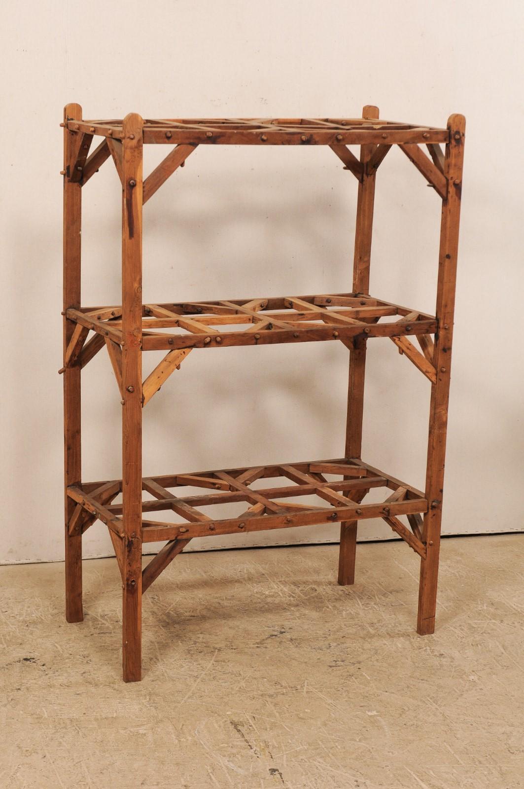 A French artistically designed wood open shelving unit from the mid-20th century. This vintage shelf from France, standing just under 5.5 feet in height and almost 2 feet deep, features two open, interior shelves, along with the additional top
