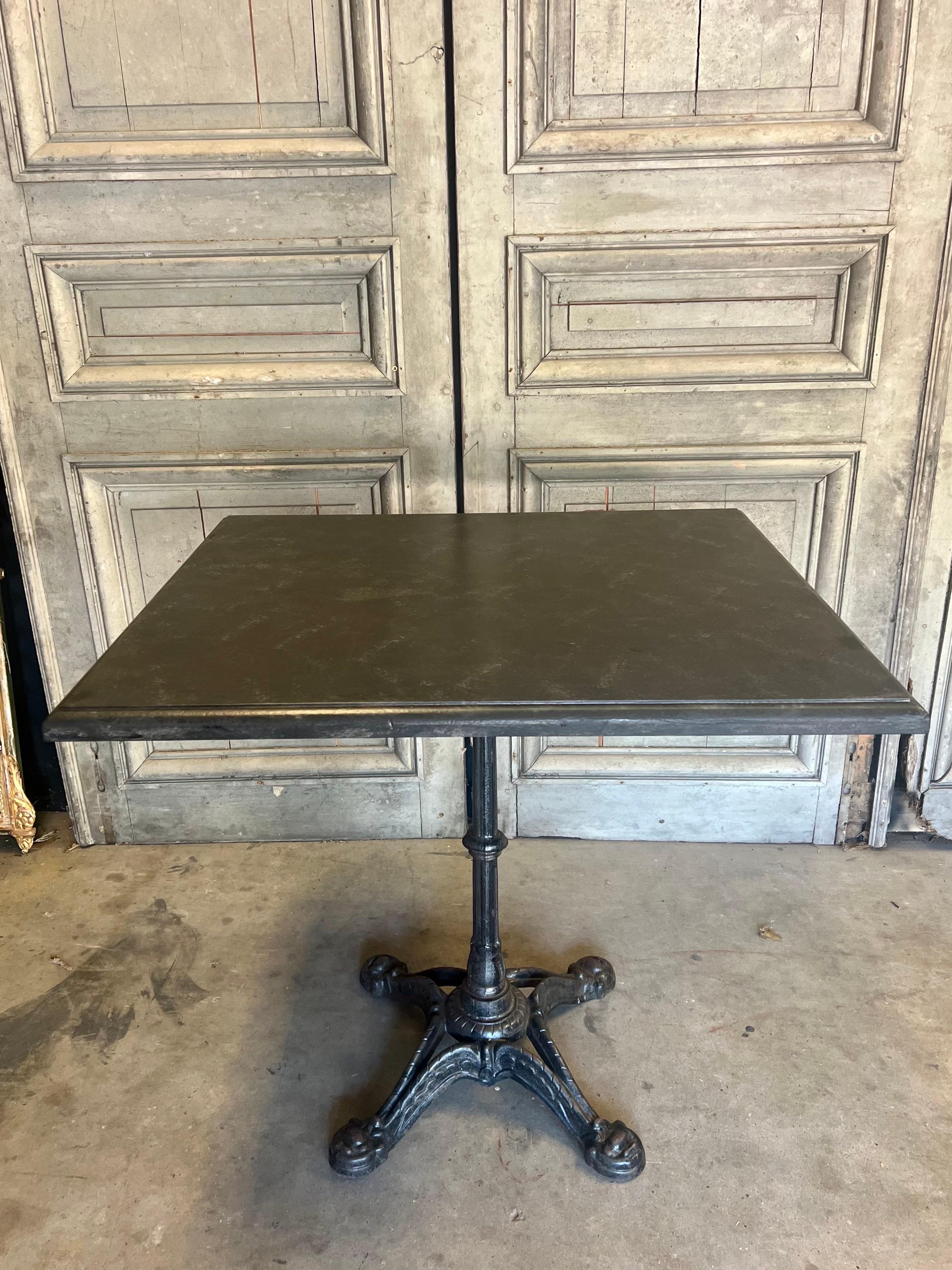 Discovered during our time in France, this vintage French iron bistro table includes a carved wood top that has been finished in a black and grey faux marble.  Suitable for indoors or covered outdoor area.   

Measures 27.5 x 31.5 x 29”h making it