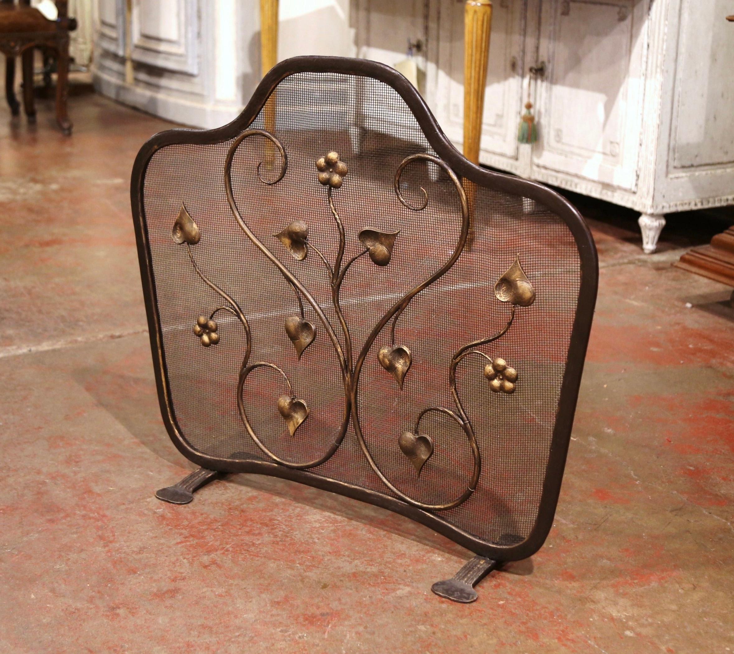 Decorate a fireplace hearth with this elegant freestanding vintage iron screen. Forged in France circa 1980, the important forged screen with arched top stands on small feet and features decorative scroll and floral motifs throughout; it is further