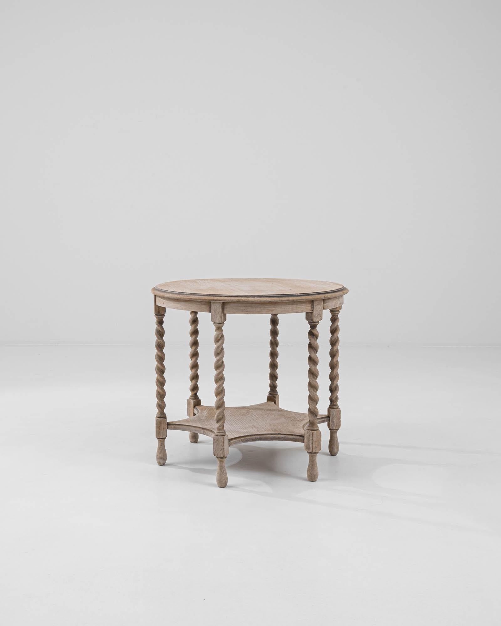 A wooden side table created in 20th century France. With spiraling legs, a star shaped lower shelf, and teardrop feet, this small table is full of surprising details and playful charm. The surface of the oak has been carefully restored through a