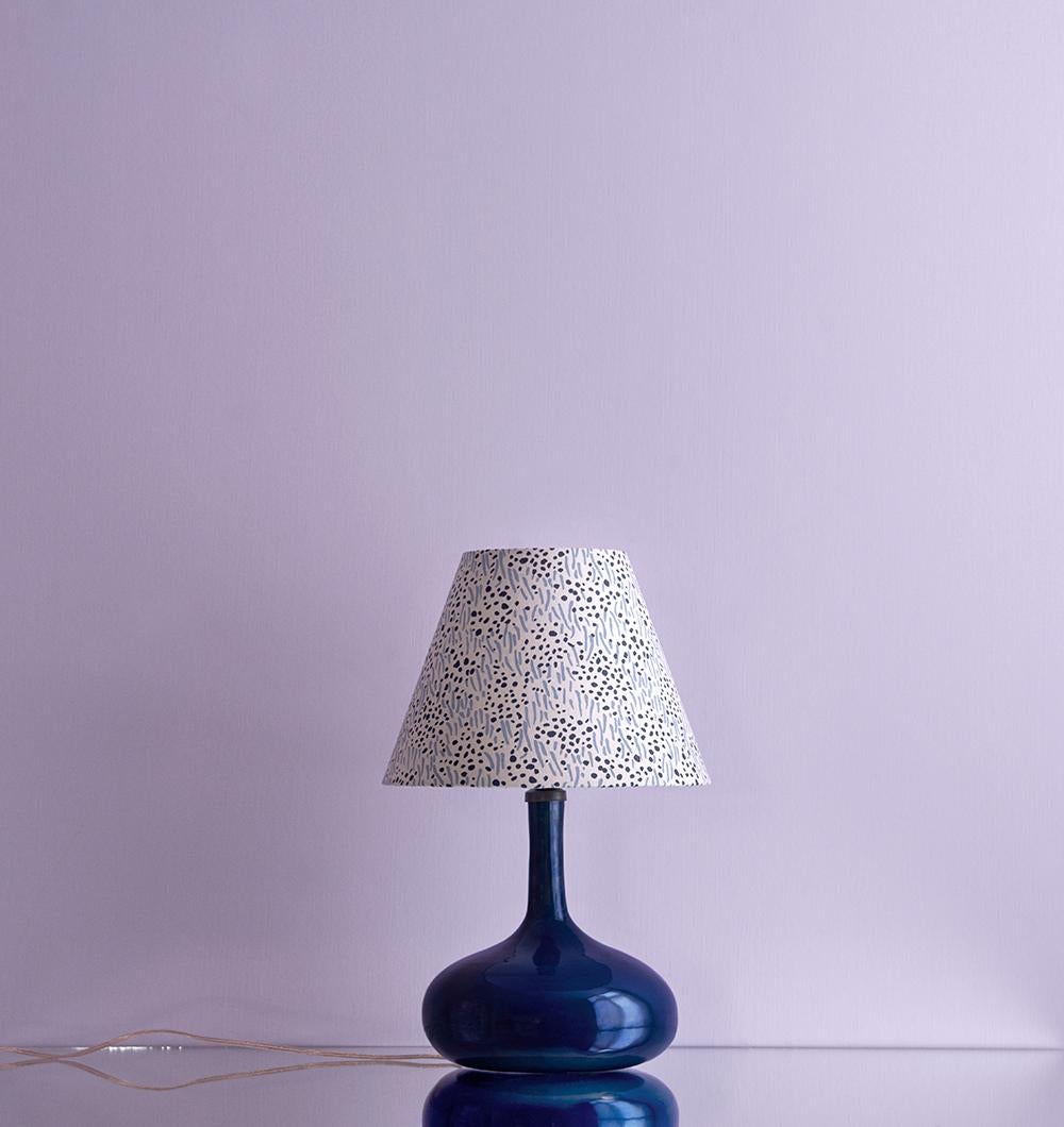 Beautiful, French vintage ceramic table lamp in a deep blue. The lamp is paired with a customized lampshade with navy and Carolina blue patterns.
 