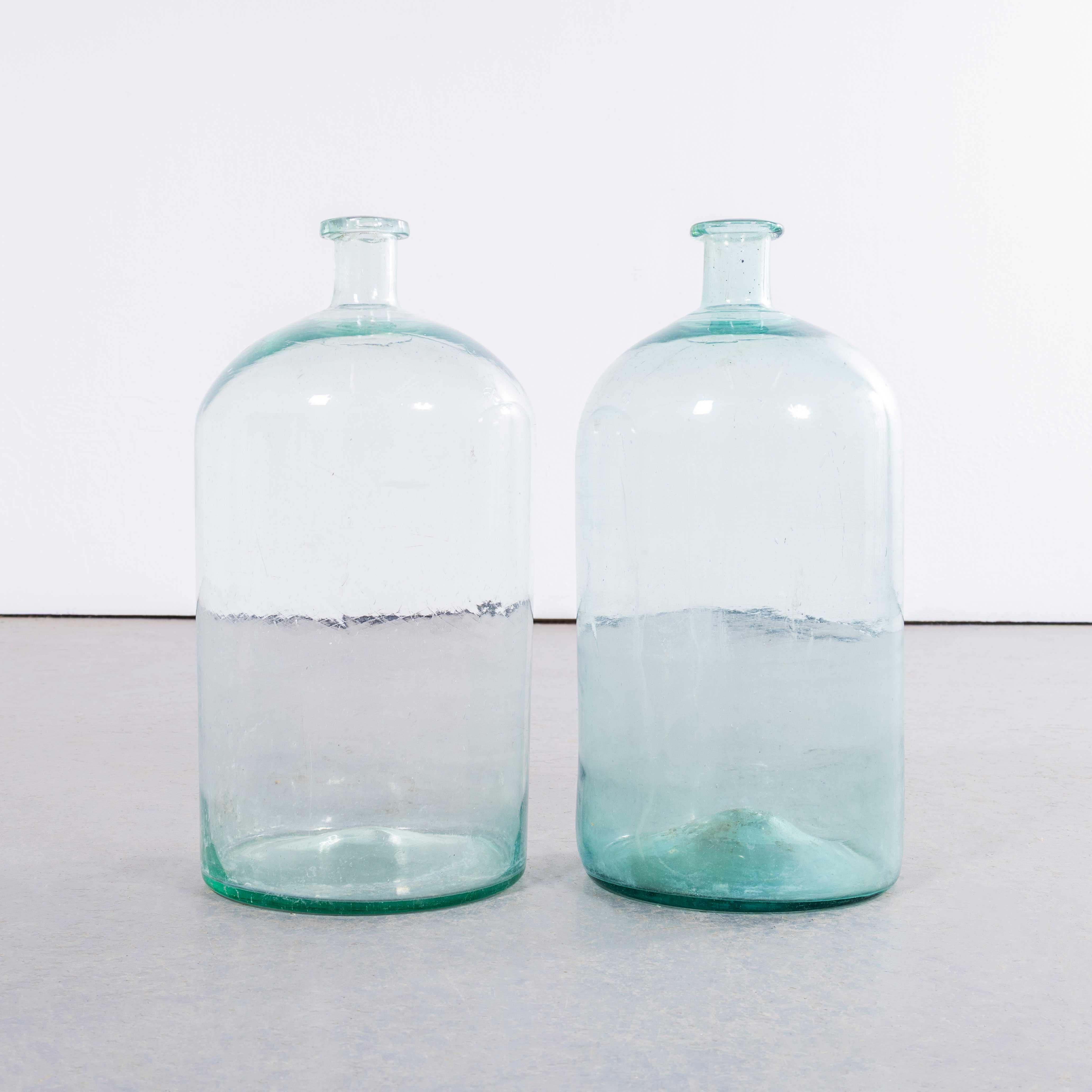 Garrafas francesas vintage de vidrio azul y transparente - Pareja. 

Un par de damajuanas de vidrio soplado a boca utilizadas como recipientes tradicionales, principalmente para almacenar y transportar vino. Estas damajuanas se han limpiado