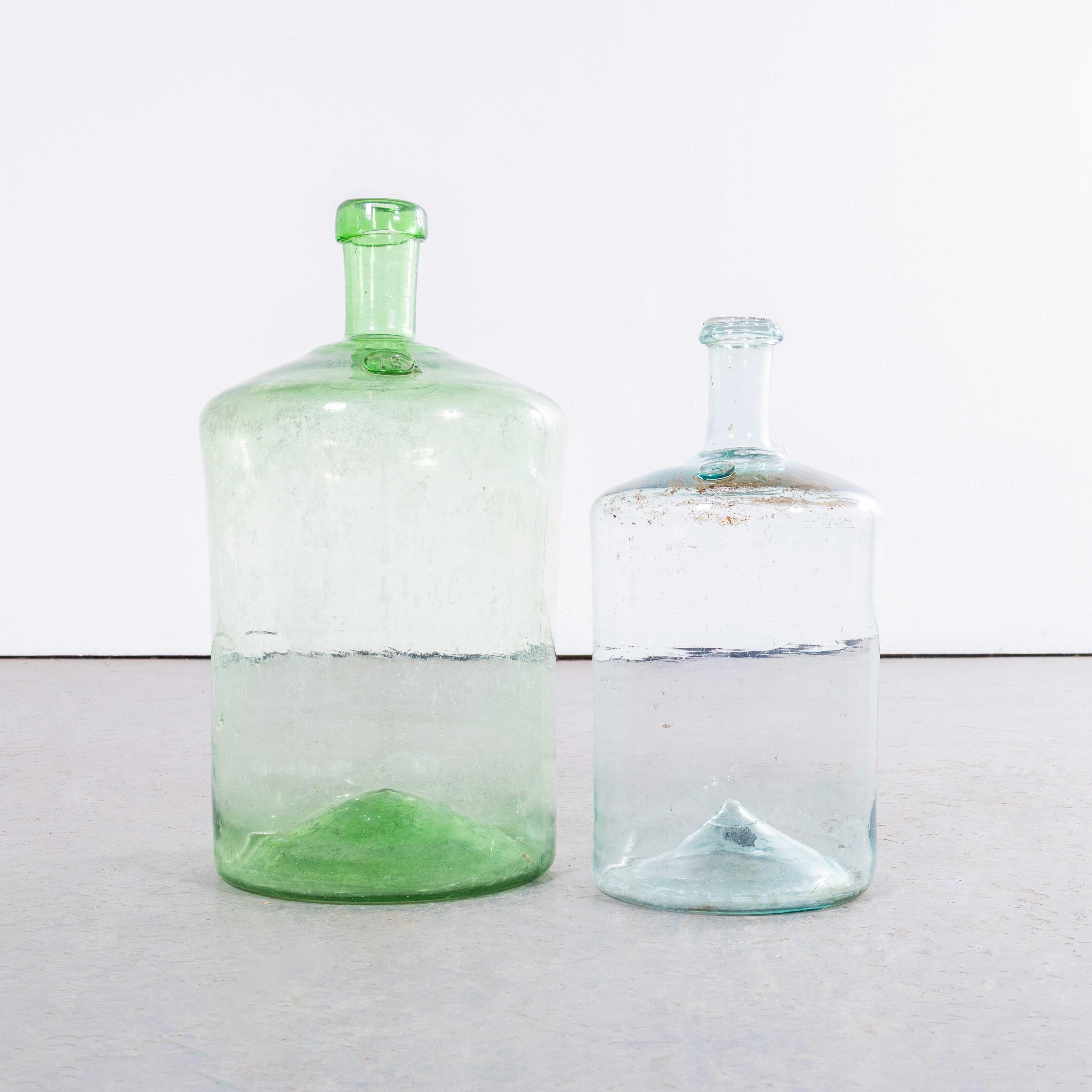 Bottiglia francese vintage in vetro verde e blu trasparente - Coppia. 

Una coppia di damigiane in vetro soffiato a bocca utilizzate come contenitori tradizionali principalmente per la conservazione e il trasporto del vino. Queste damigiane sono