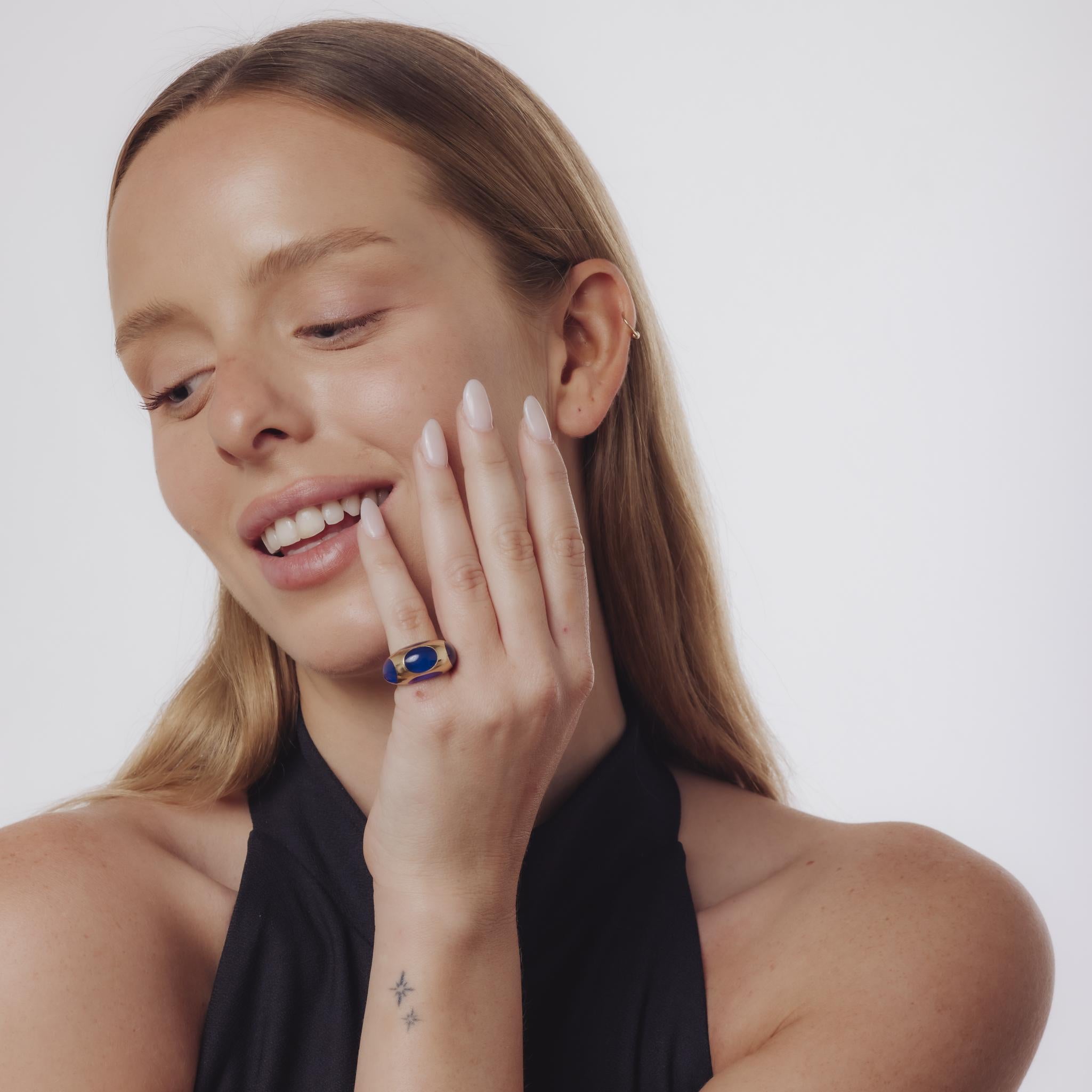 Questo sorprendente anello vintage degli anni '70 sfoggia una vivida resina blu incorniciata in oro giallo 18 carati, evidenziata da marchi francesi per una dichiarazione audace ma raffinata.