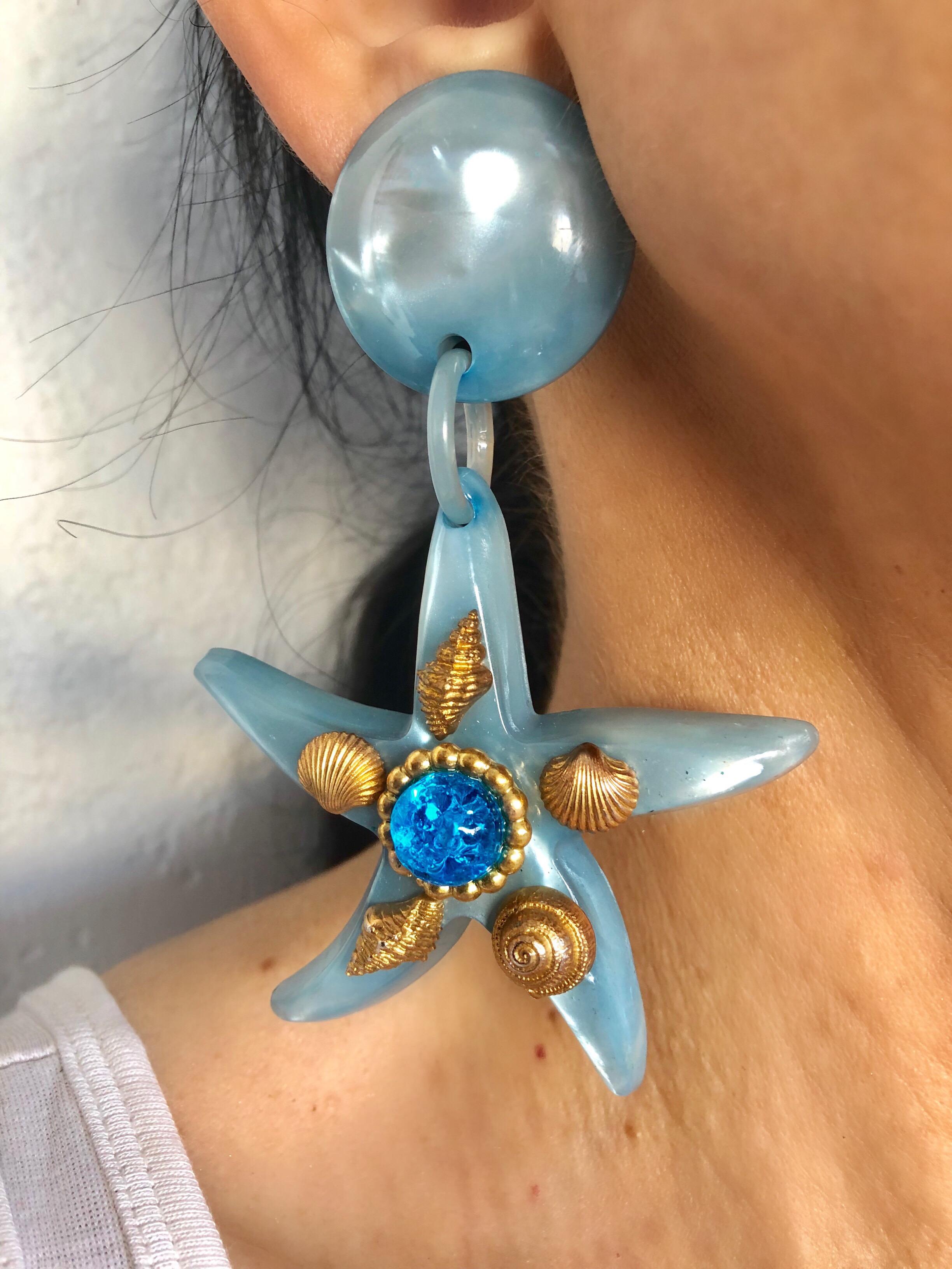 Monumental and scarce vintage pair of starfish statement clip-on earrings by Dominique Aurientis, Paris - made in Paris. The chic pair of earrings is comprised of a light-blue iridescent resin - which is adorned by gilt seashells and a large poured