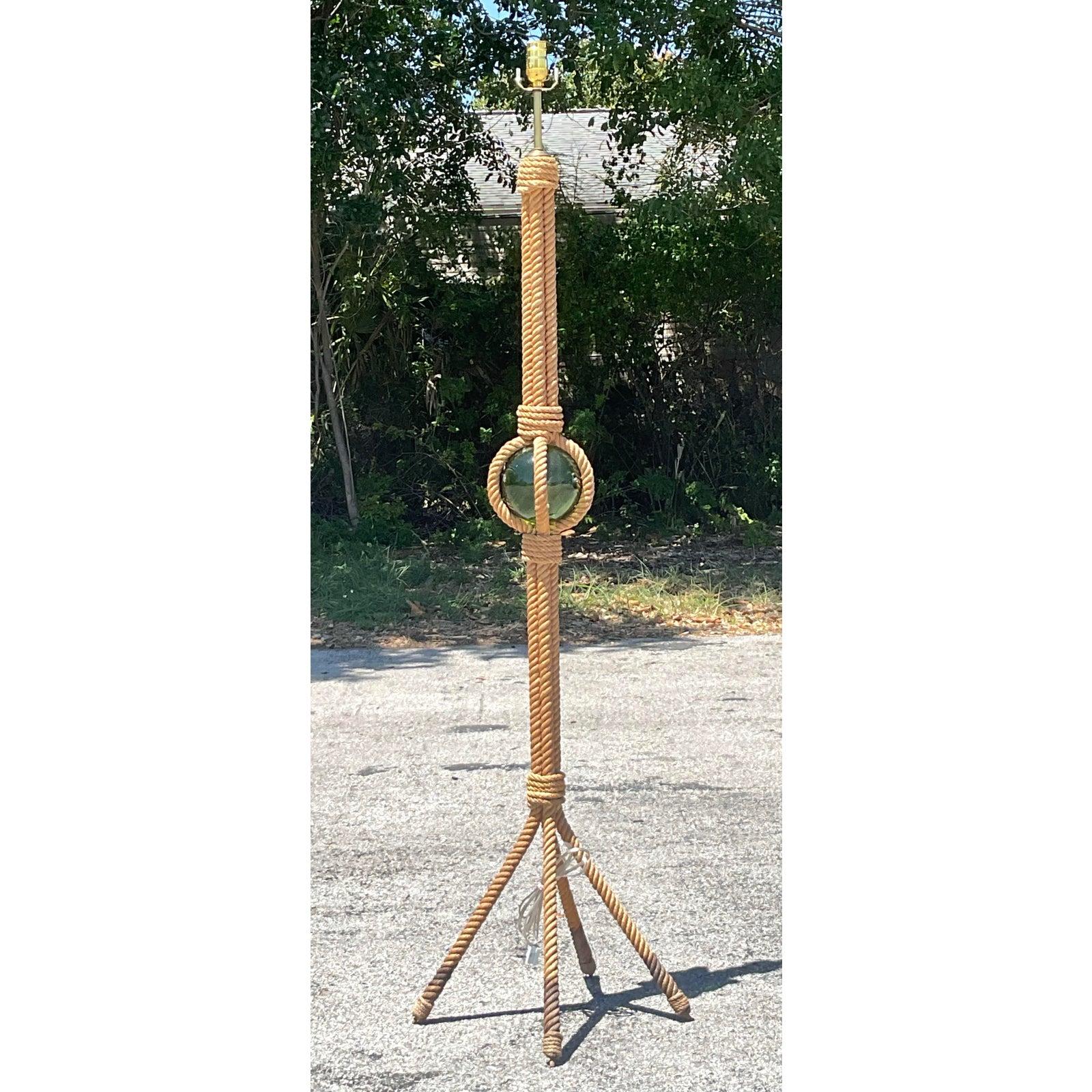 Verleihen Sie Ihrem Raum maritimen Charme und skulpturale Eleganz mit dieser von Minet inspirierten französischen Boho-Stehlampe im Vintage-Stil. Die schlanke Form der Leuchte, die kunstvoll mit einem dicken Juteseil umwickelt ist, wird durch eine