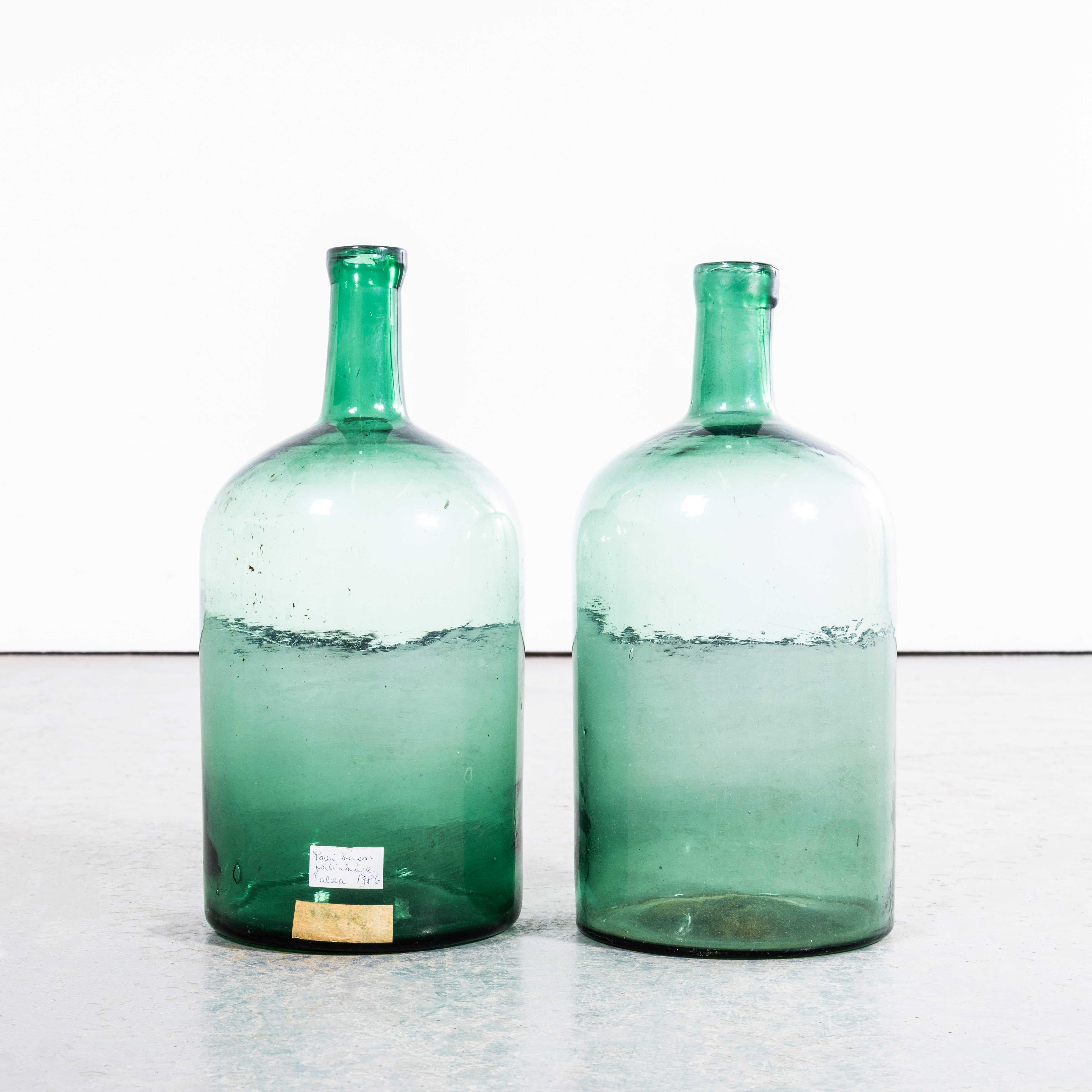 Damigiane francesi vintage in vetro verde - Coppia. 

Una coppia di damigiane in vetro soffiato a bocca utilizzate come contenitori tradizionali principalmente per la conservazione e il trasporto del vino. Queste damigiane sono state pulite con