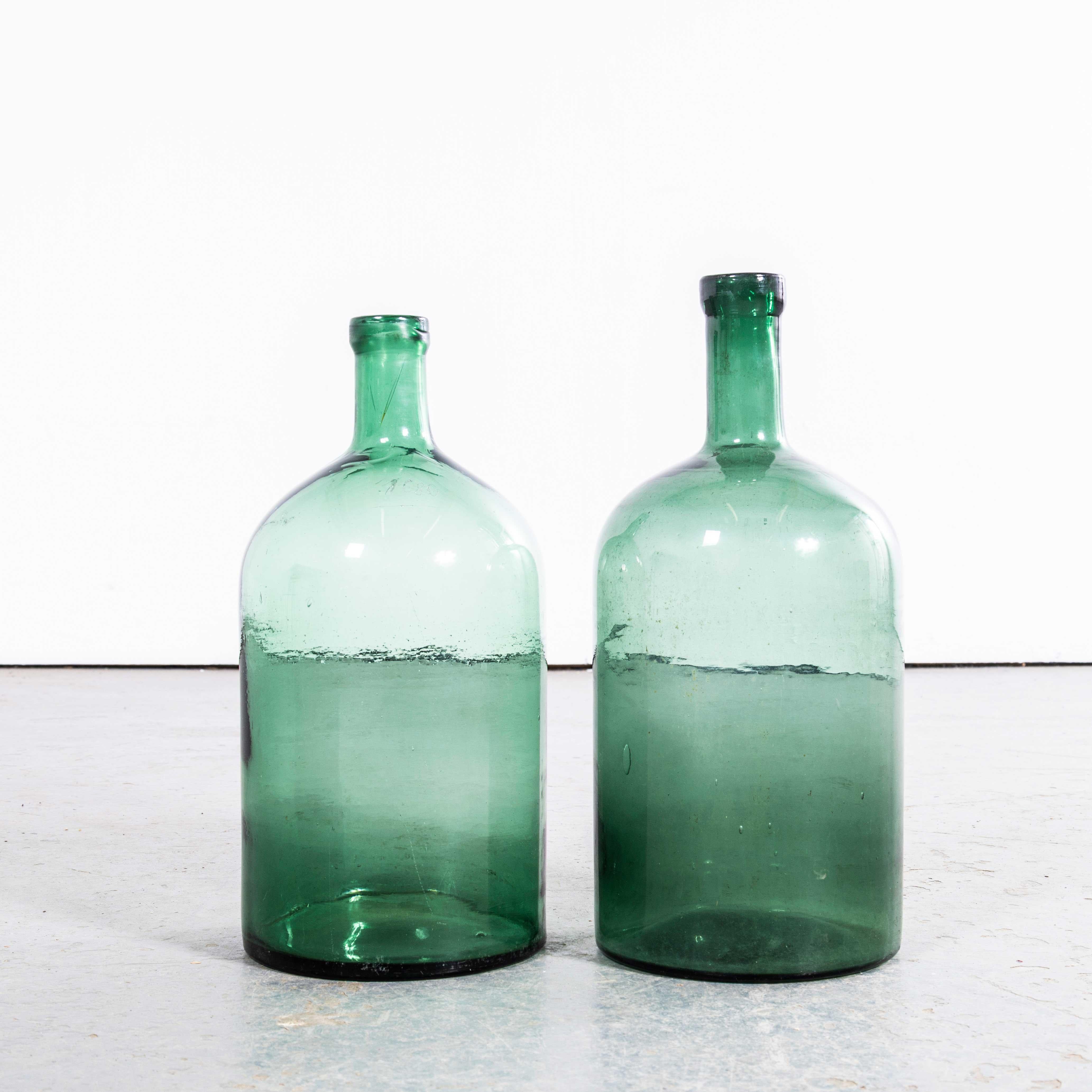 Damigiane francesi vintage in vetro verde - Coppia. 

Una coppia di damigiane in vetro soffiato a bocca utilizzate come contenitori tradizionali principalmente per la conservazione e il trasporto del vino. Queste damigiane sono state pulite con