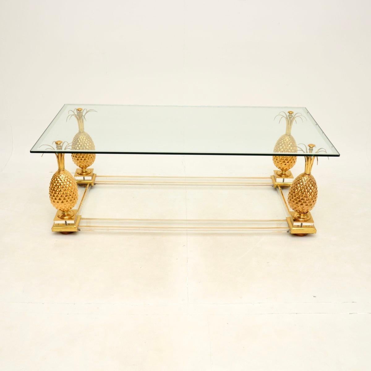 A stylish and very well made vintage French brass and glass coffee table. This is very much in the manner of Maison Charles, it was made in France and dates from around the 1970’s.

It is of lovely quality, with a chunky brass pineapple supporting