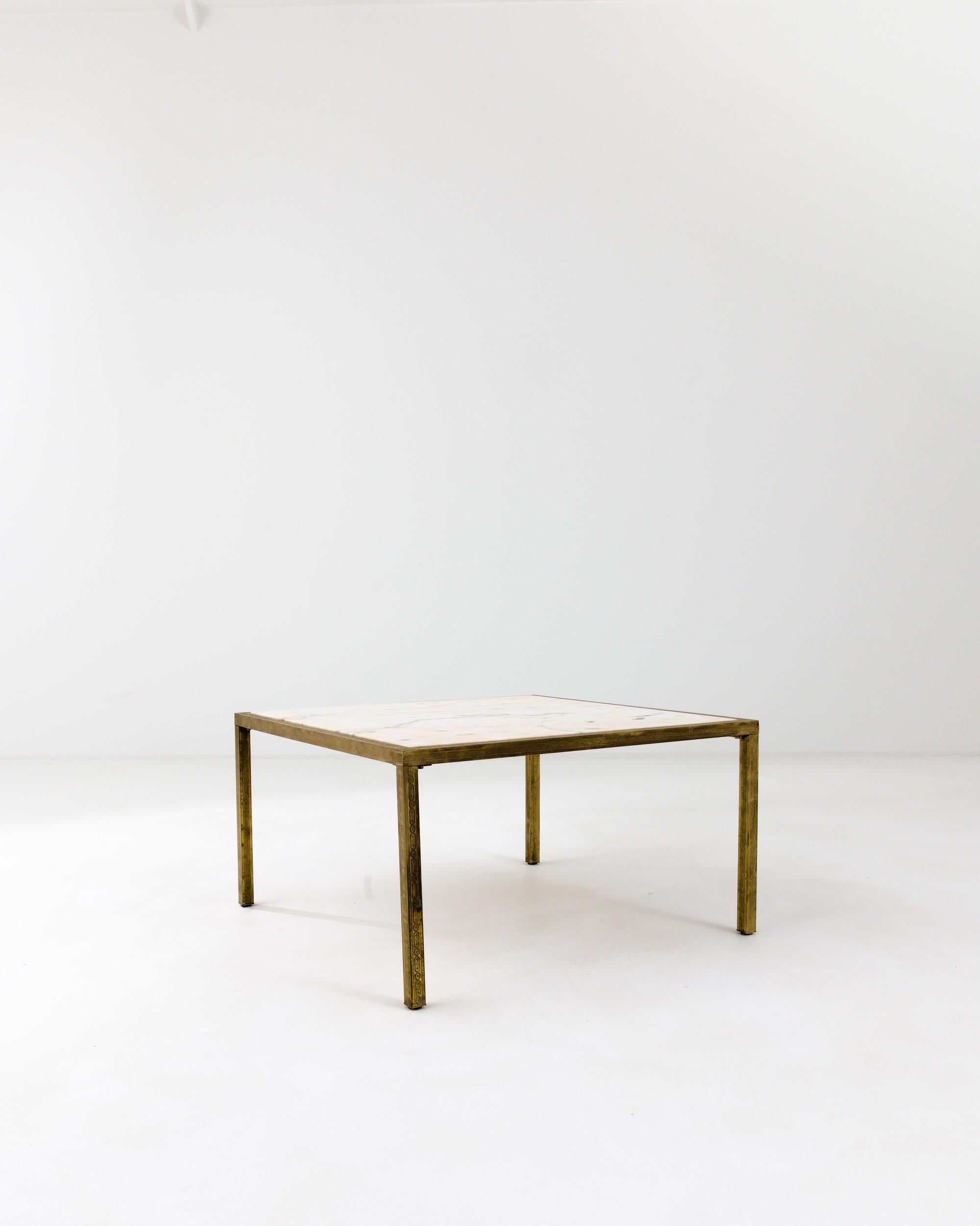A geometric brass coffee table with marble top from 20th century France. The clever connection of brass legs craft a pleasing geometry. Tasteful molded details add an art nouveau sensibility to the table’s bold form, enhanced by a subtle patina