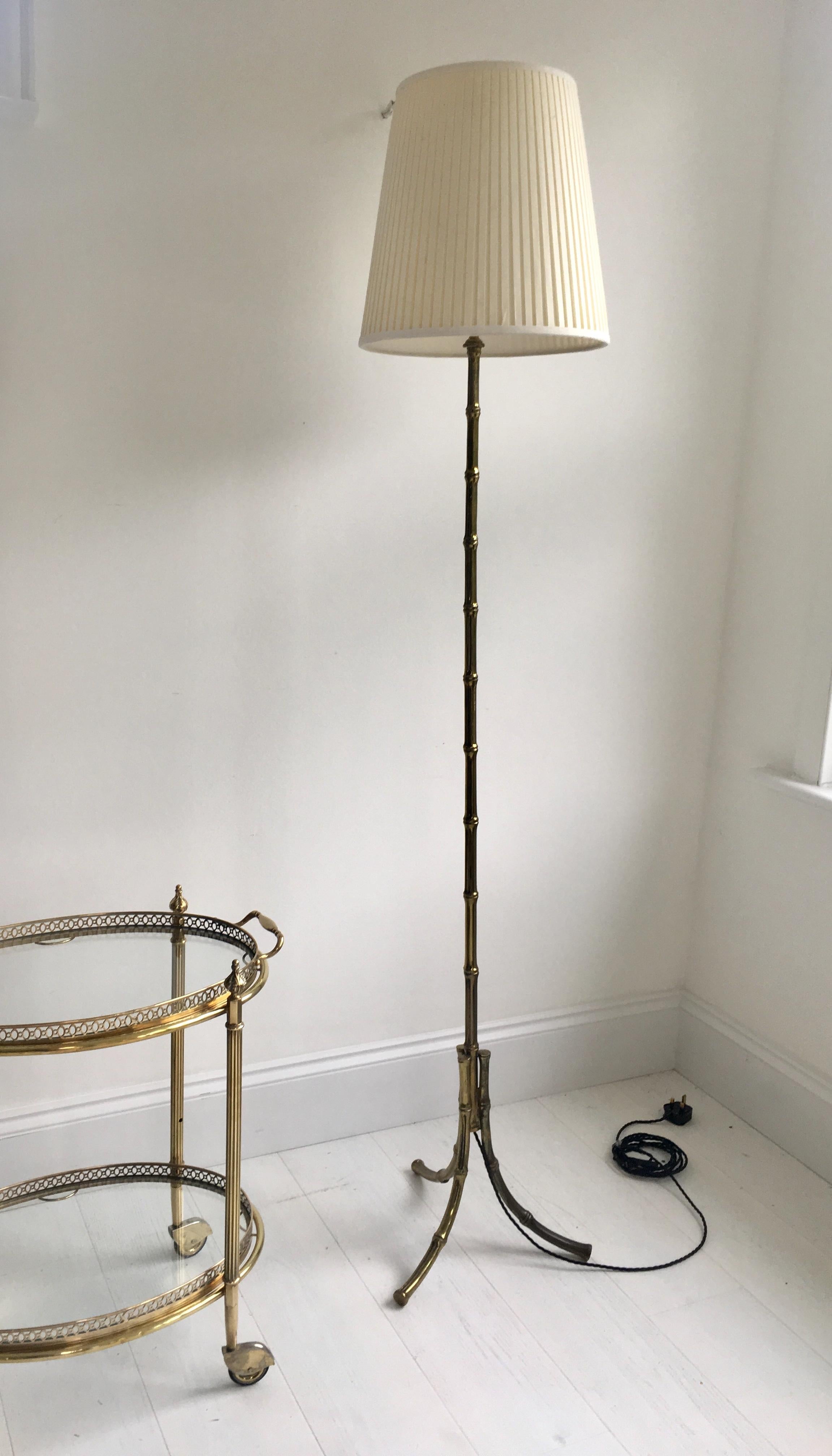 Elegant faux bamboo floor lamp from Paris, circa 1960.

Lacquered brass with aged patina.

Measures: Stands 147cm to light fitting.

Lamp shades excluded.

