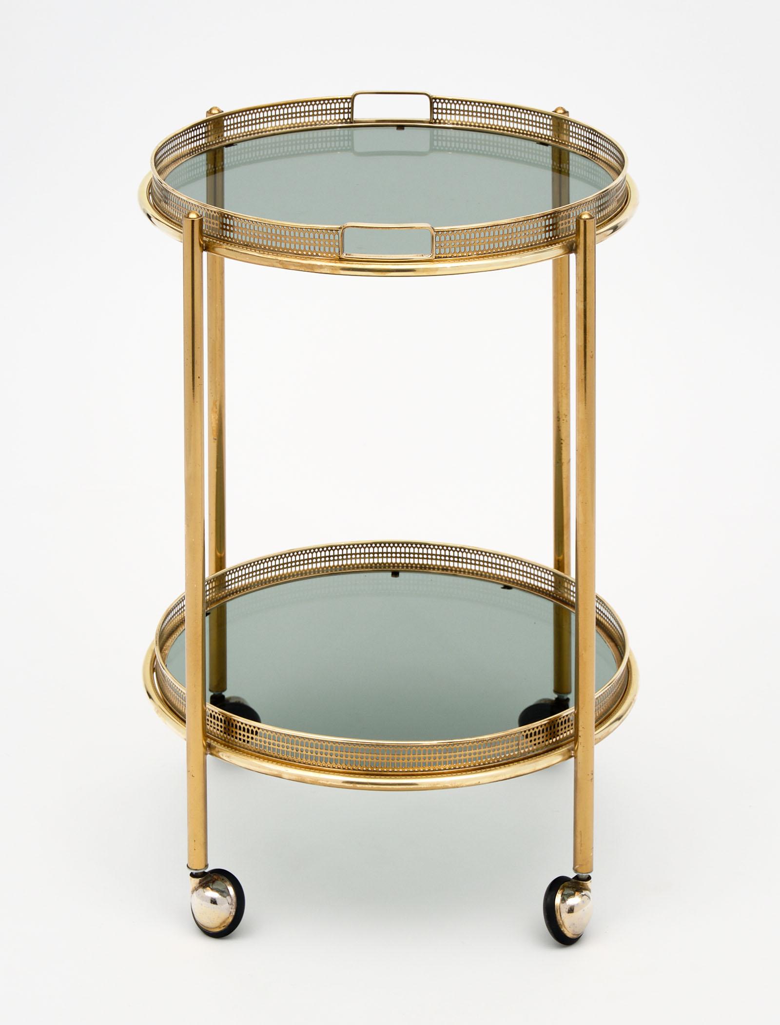 Vintage French brass bar cart with tray. We love the smoked glass and detachable top tray. The brass structure is quite sturdy and in excellent vintage condition.