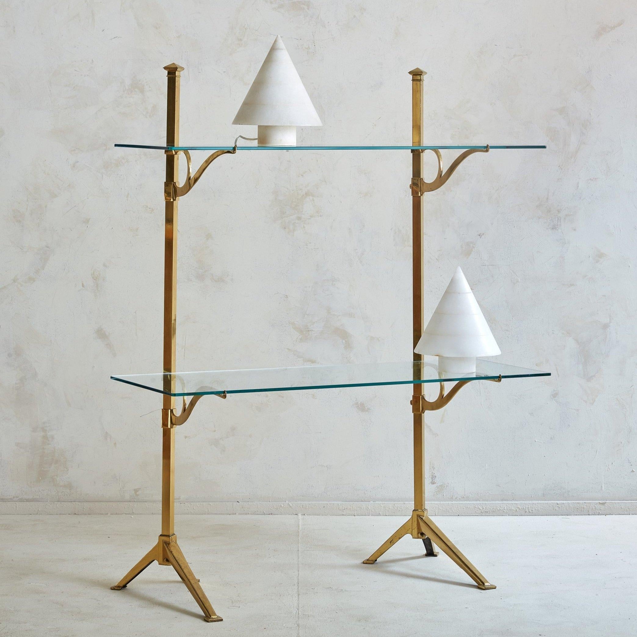 A vintage French Bistro Shelf sourced in the South of France. The unlacquered brass frame has adjustable shelves, curved brass shelf supports and looks as fabulous on the floor and it does on a counter or table top. 
 DIMENSIONS: 45.5