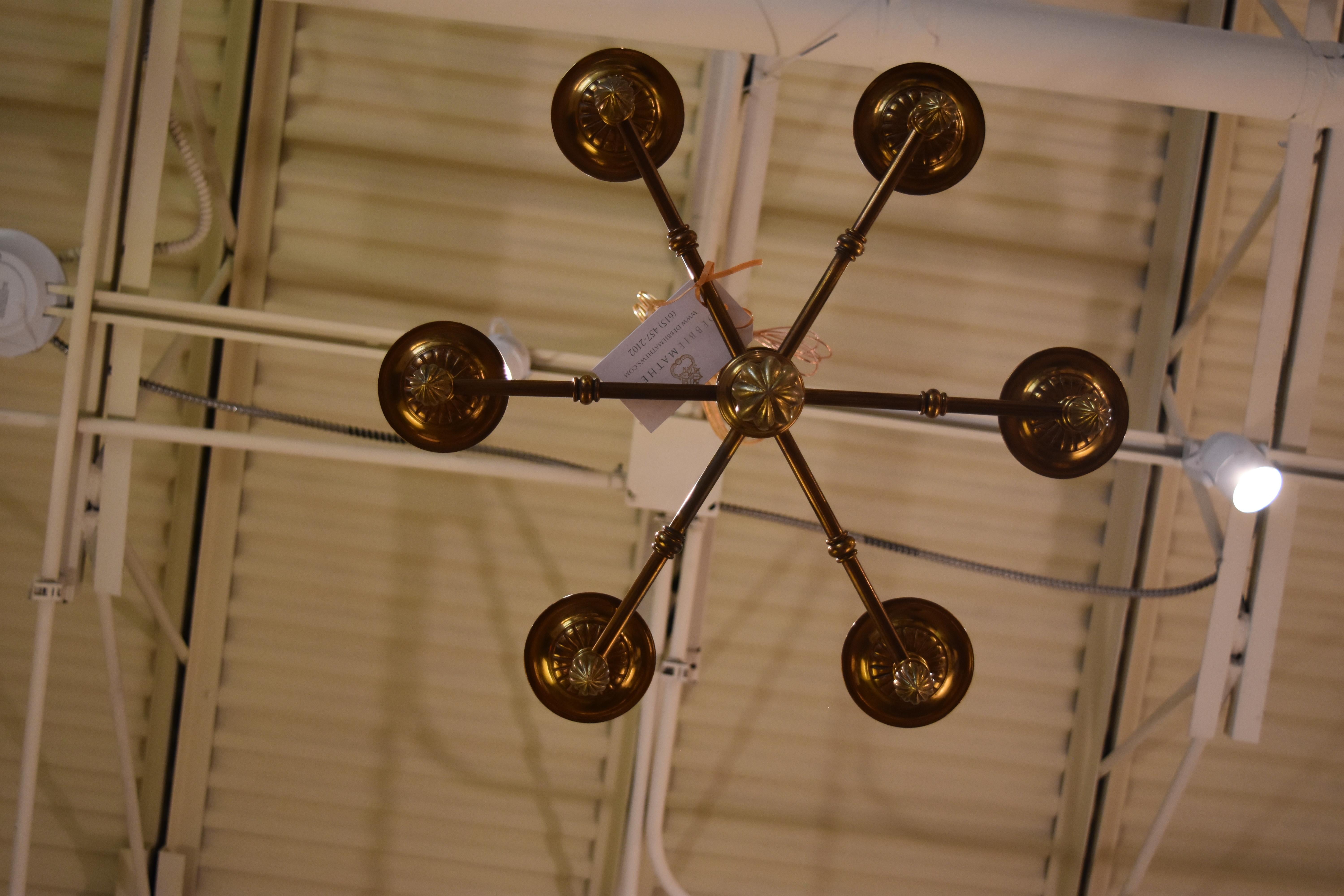This vintage French brass six-light chandelier has been newly rewired for American use. The aged brass patina and black candle covers make it a handsome piece for a library or study.