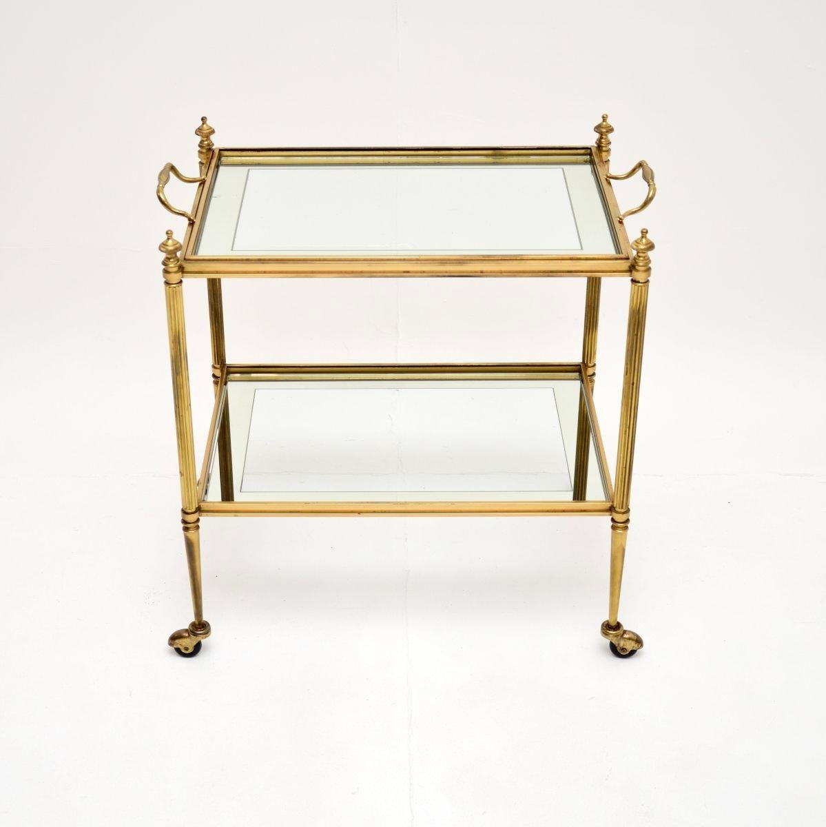 A stylish and very well made vintage French brass drinks trolley, dating from the 1950-60’s.

This is beautifully designed and is of lovely quality. It is quite petite, the inset glass shelves have a mirrored border and can be removed. The top