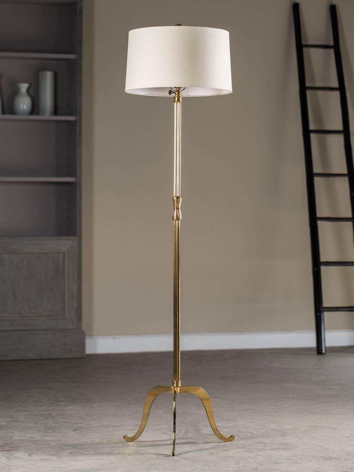 What legs. The handsome flat brass legs of this vintage French brass floor lamps circa 1940 are eye catching. The broad upper section narrows to a pert curve at the base near the floor on each of the three legs and throws attention on the simplicity