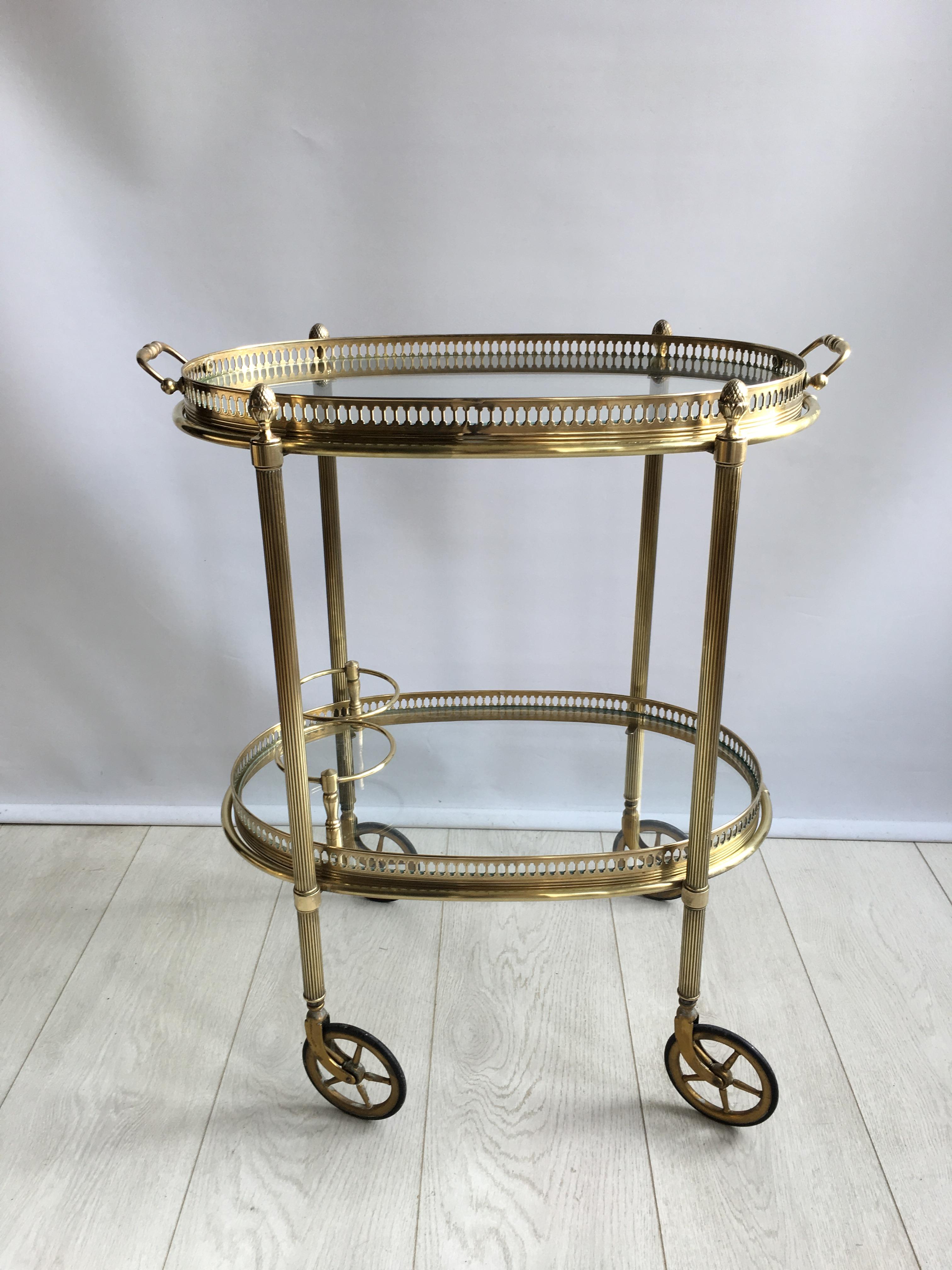 Attractive vintage drinks trolley from France, circa 1950.

Polished brass frame with lift off top tray and bottle holder to lower tier

Perfect for smaller spaces

Measures: Overall dims 56cm wide, 33cm deep and 65cm tall (62cm to glass).