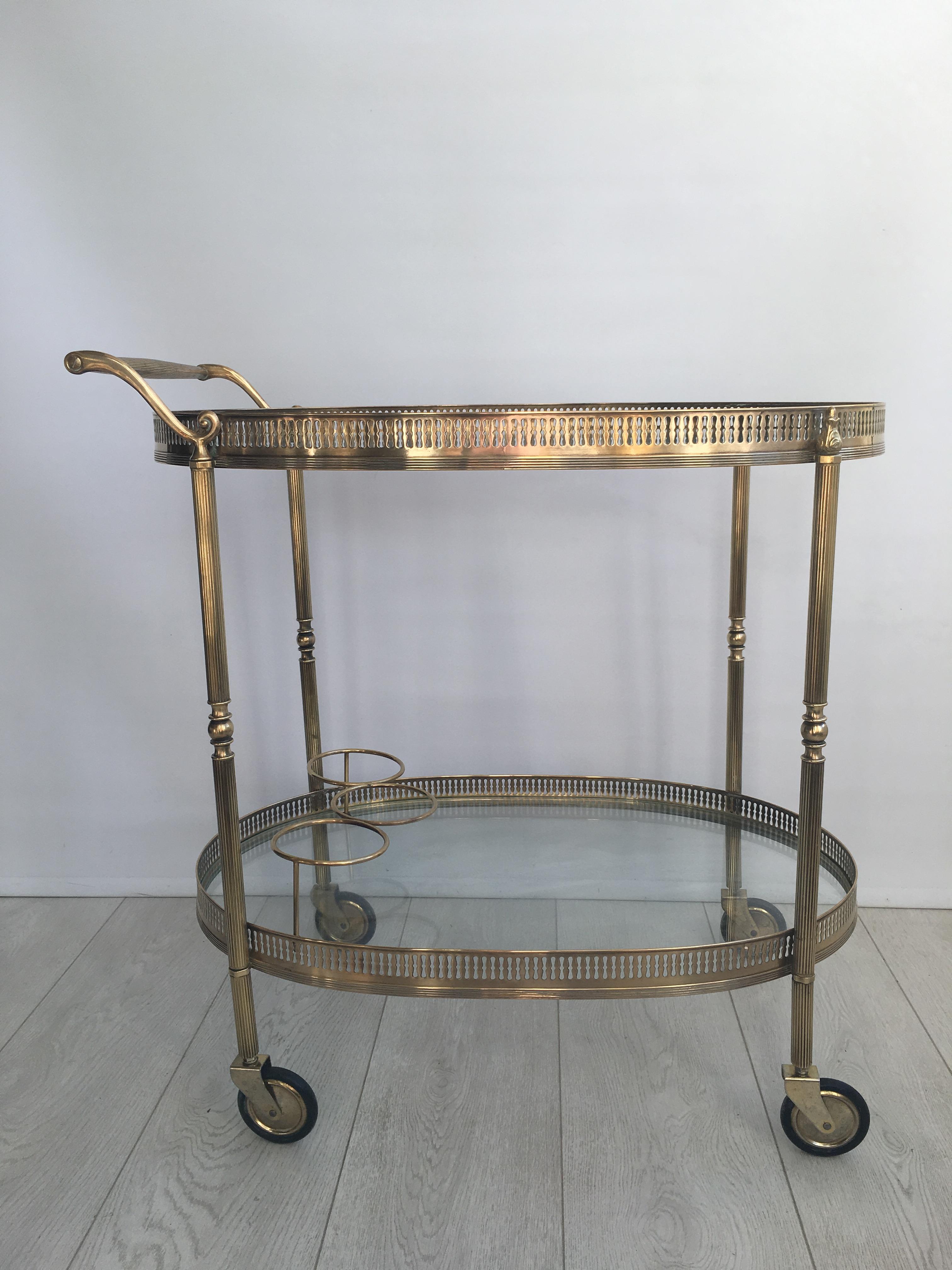 Great shape to this sizable drinks trolley from France, circa 1950.

Polished brass frame with bottle holder to lower tier.

Measures: Top tray measures 65.5cm wide, 41cm deep and stands 62.5cm to glass
Overall dimensions 68cm wide, 41cm deep