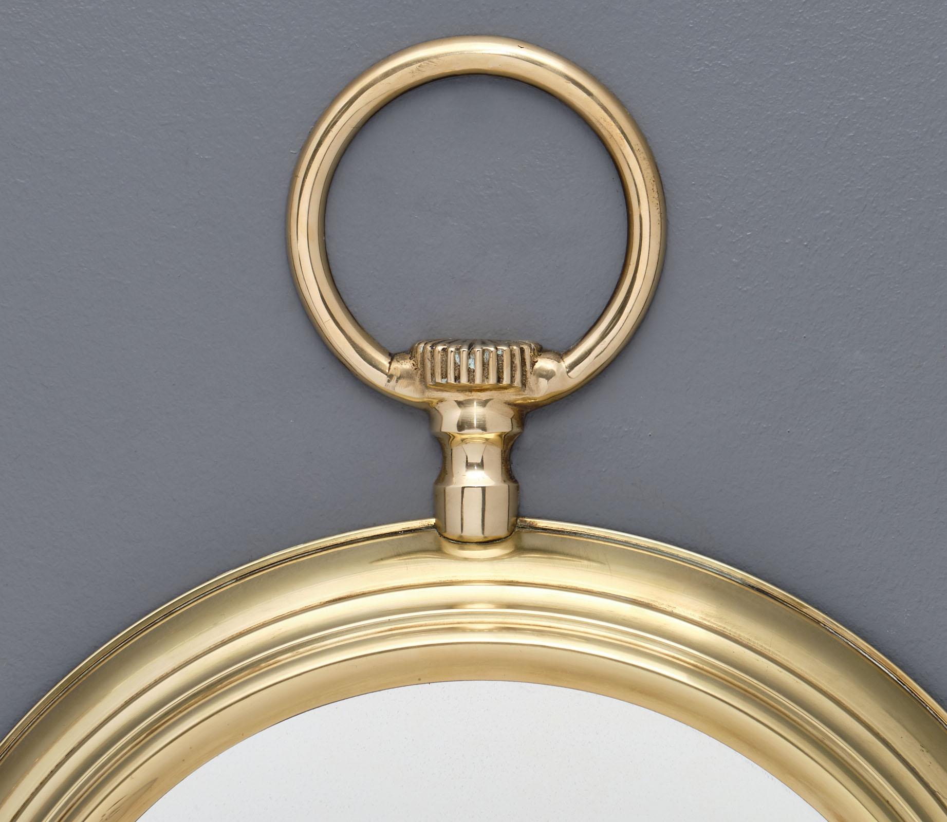 A French brass vintage pocket watch mirror from the Art Deco period with a circular central mirror.