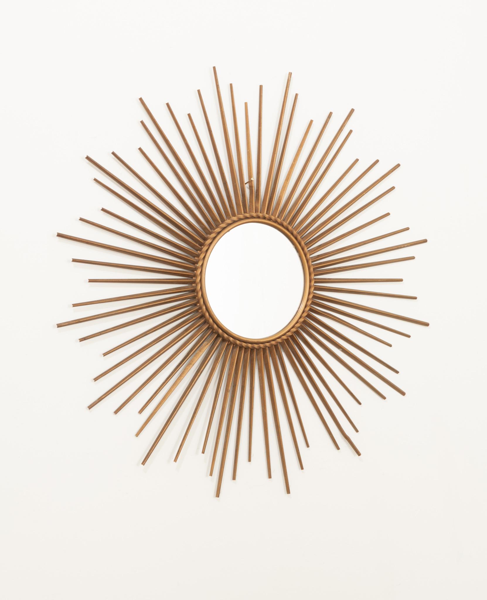 A fantastic Mid-Century Modern decor piece for any space. Sharp brass spikes radiate from the circular vintage mirror plate. The back indicates it was manufactured by Chaty Vallauris, a popular company during the 1960s. In great vintage condition.